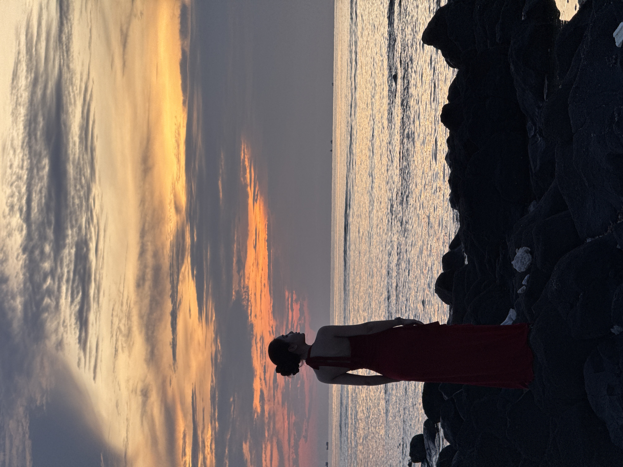Sunset on Lý Sơn Island: red dress, rocky shore, lighthouse