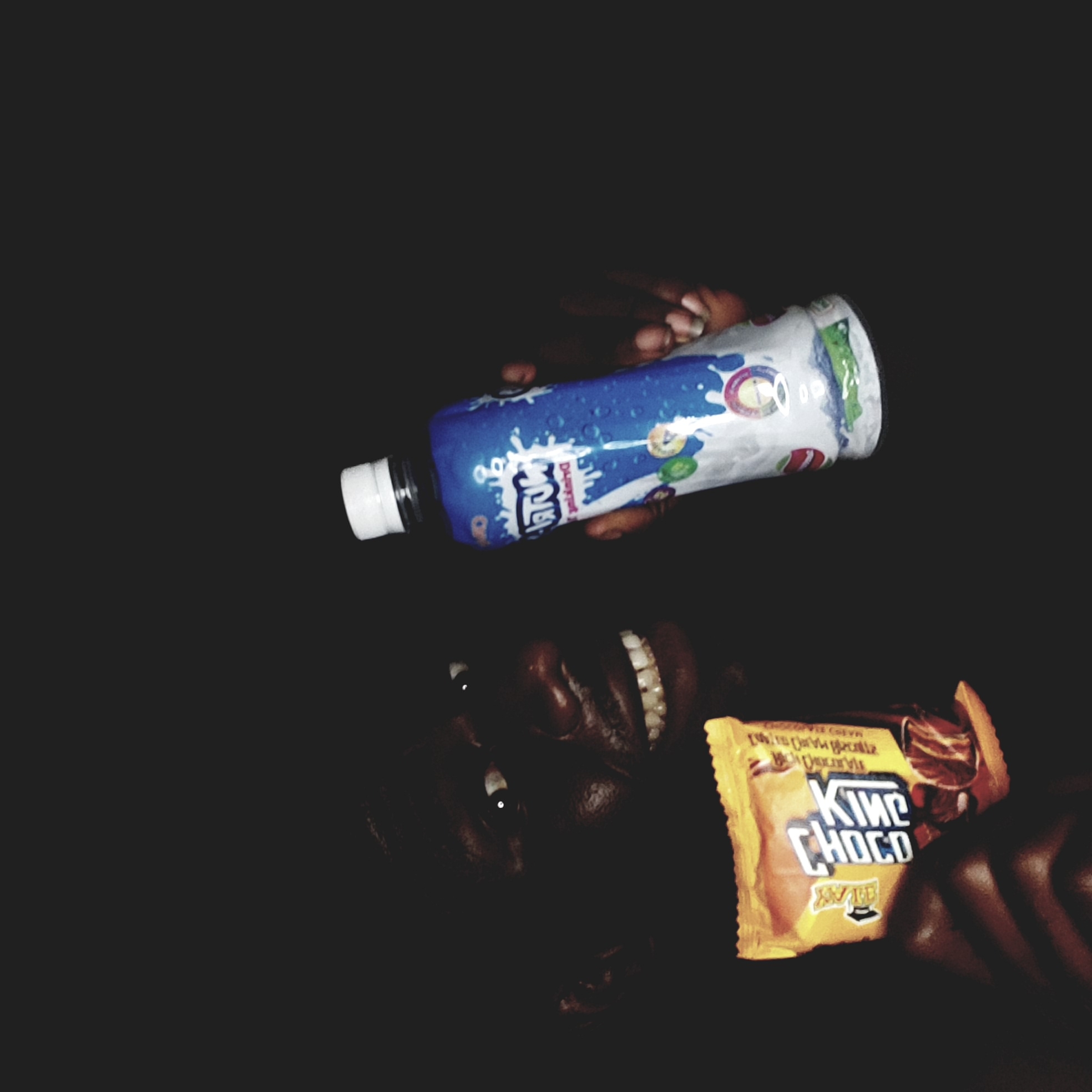 Person photographed with snacks in darkness, Narayi Nigeria
