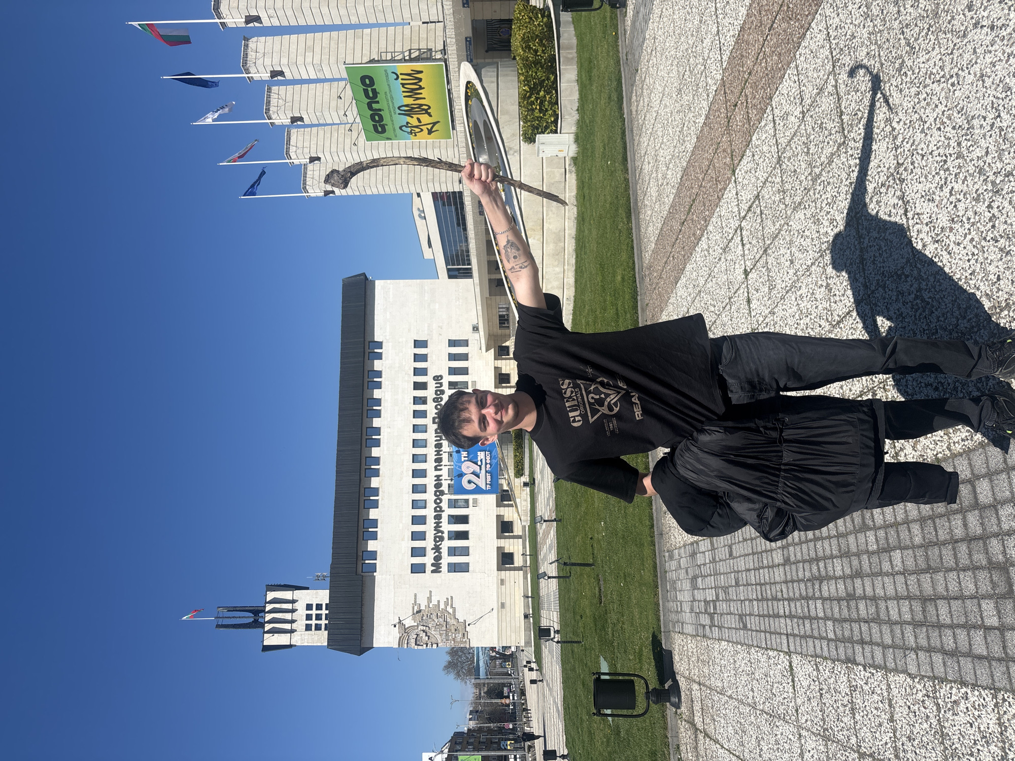 Man holds branch outside Plovdiv International Fair building