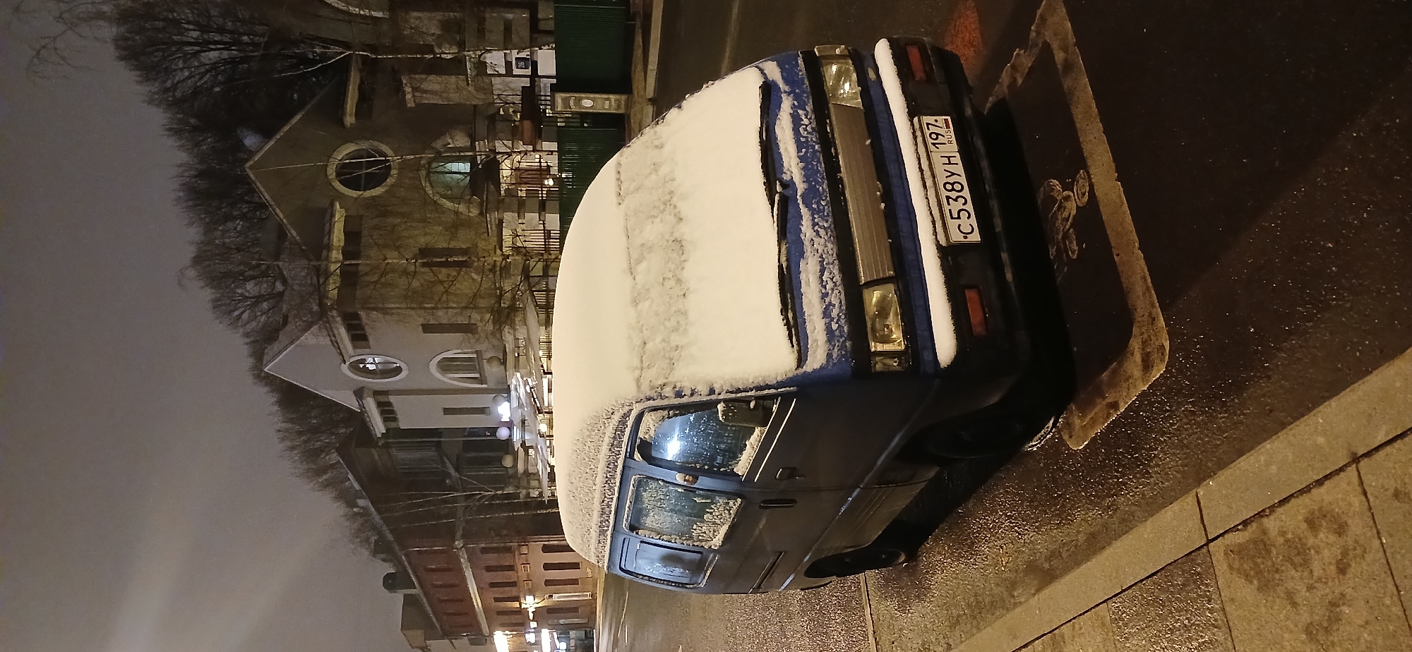 Snow-covered minivan displays children's drawings in Moscow street