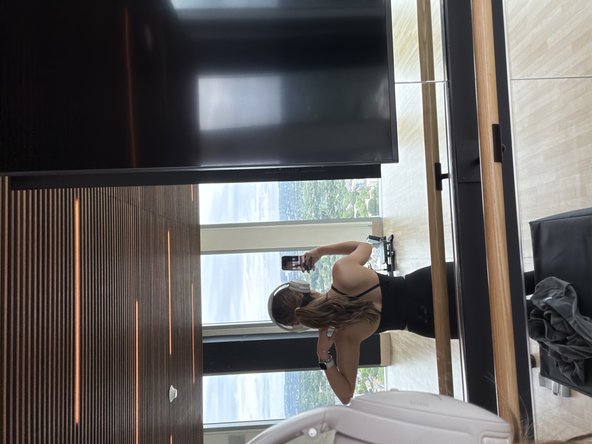Woman takes selfie by window in Austin workout gear