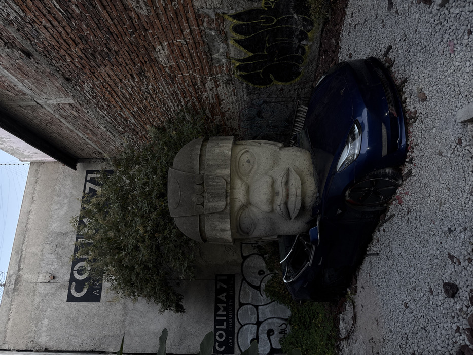 Blue Tesla meets ancient Olmec sculpture in Mexico City street art scene