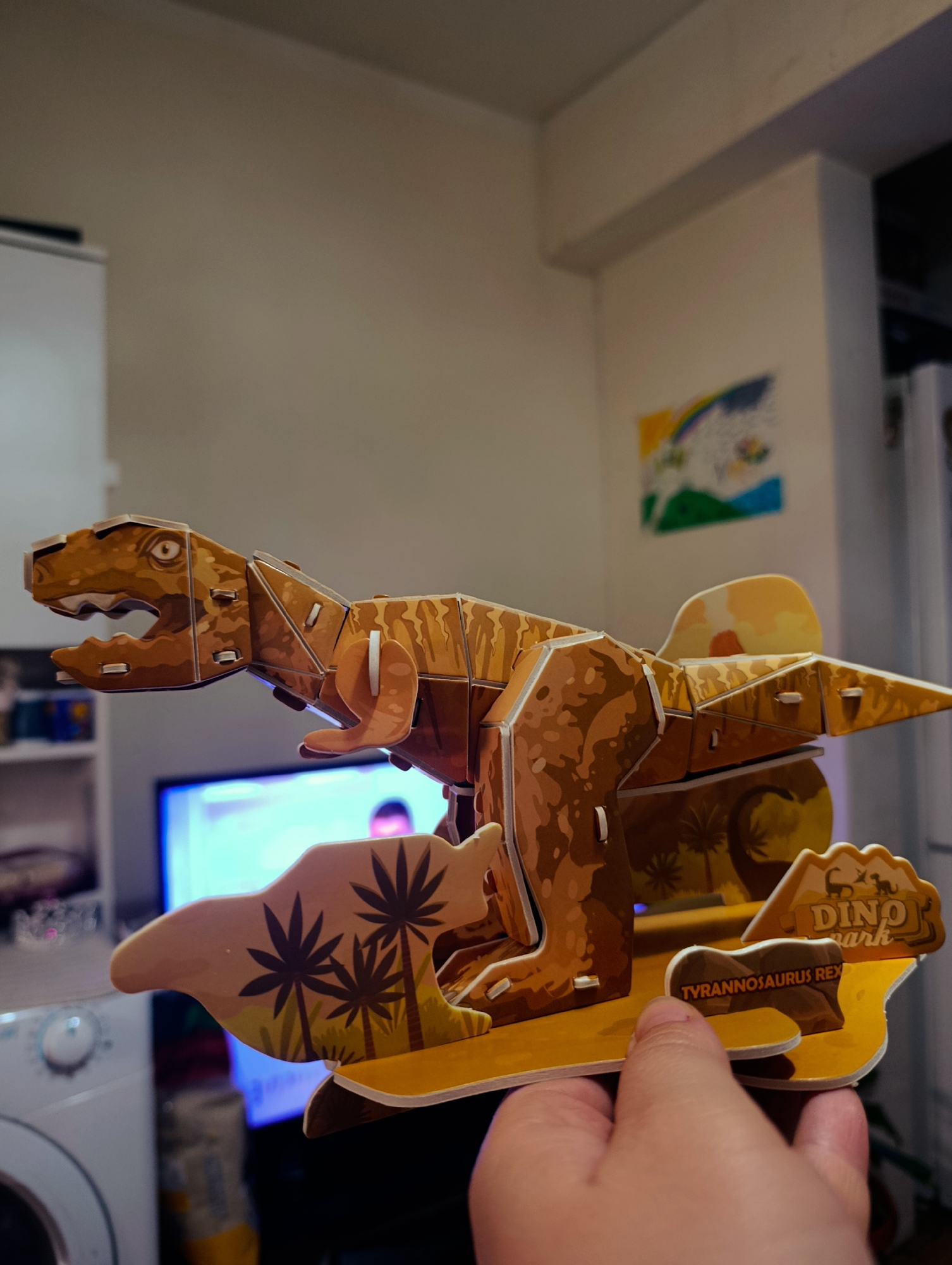 Person displays dinosaur puzzle in Bulgarian home setting