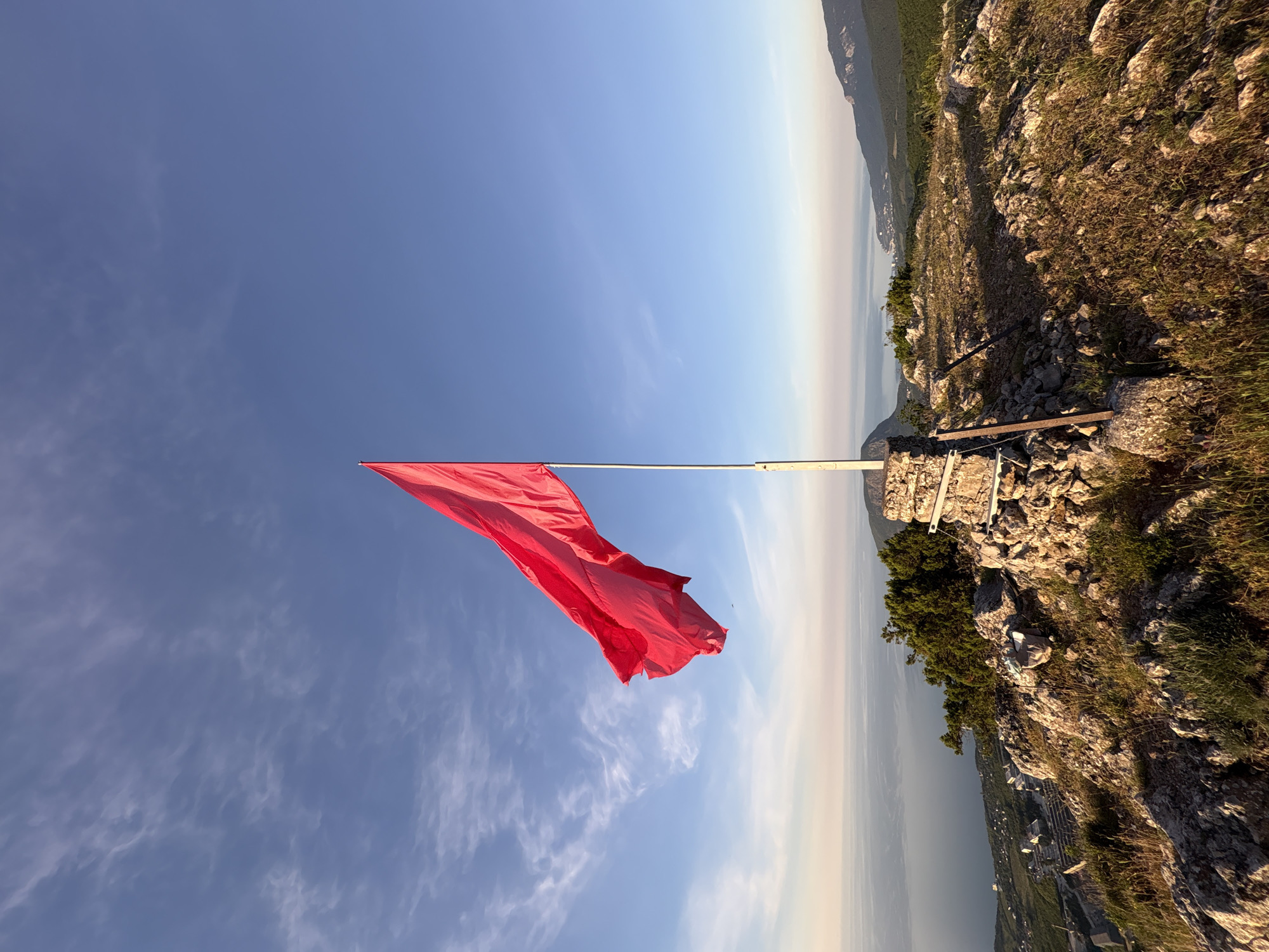 Woman documents mountaintop sunrise with red flag in Ukraine
