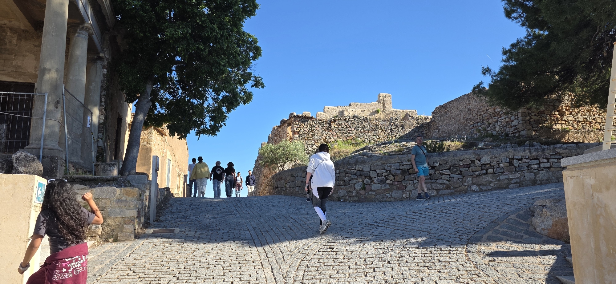Tourists explore historic Sagunto Castle ruins on spring afternoon