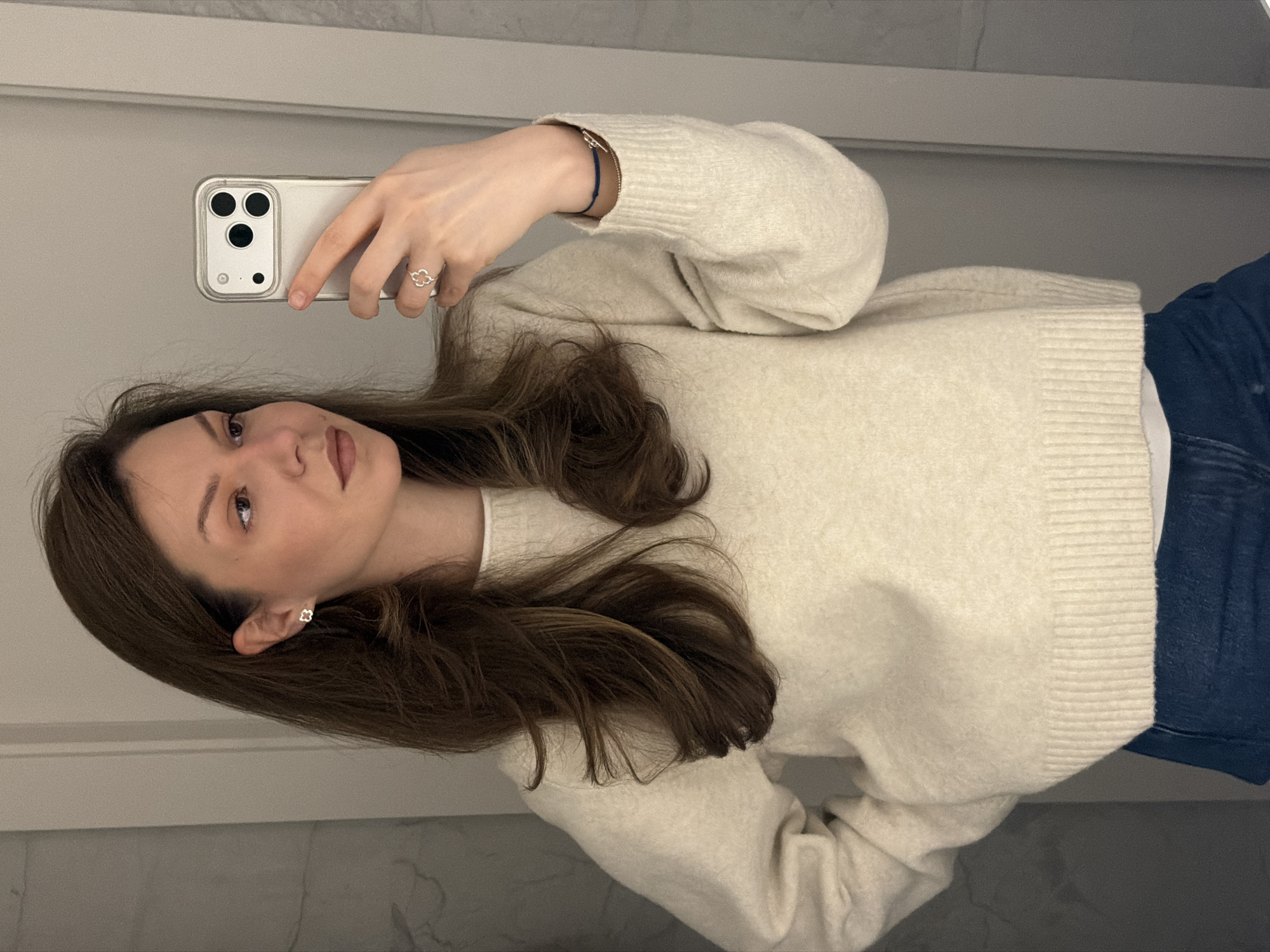 Woman takes early morning selfie in Riga wearing clover jewelry