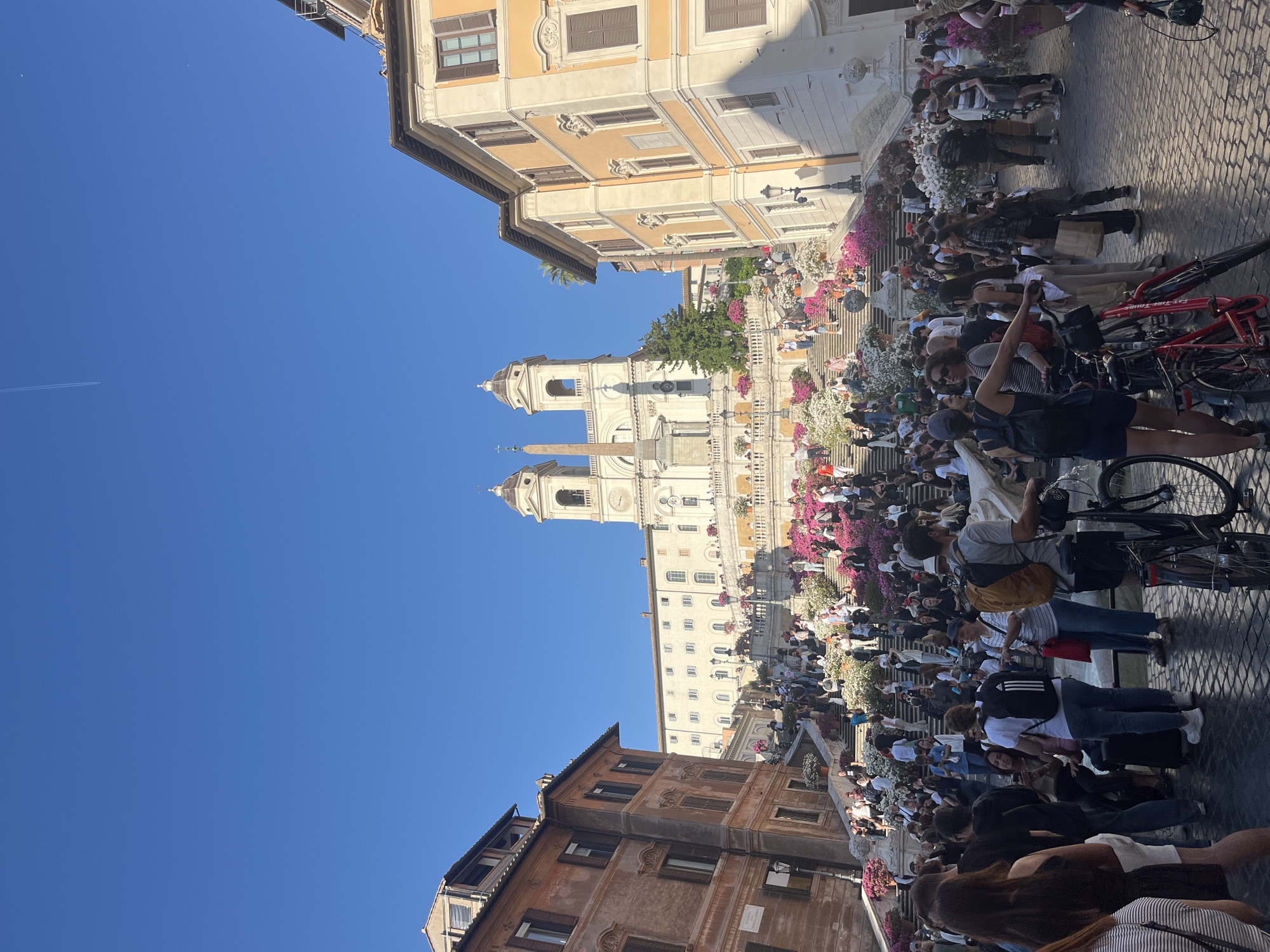 Crowds gather at Rome's Spanish Steps under clear skies