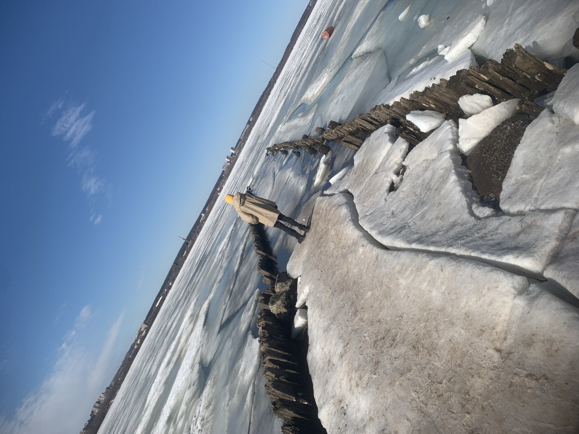 Person walks frozen breakwater at Izhevsk Pond during early morning