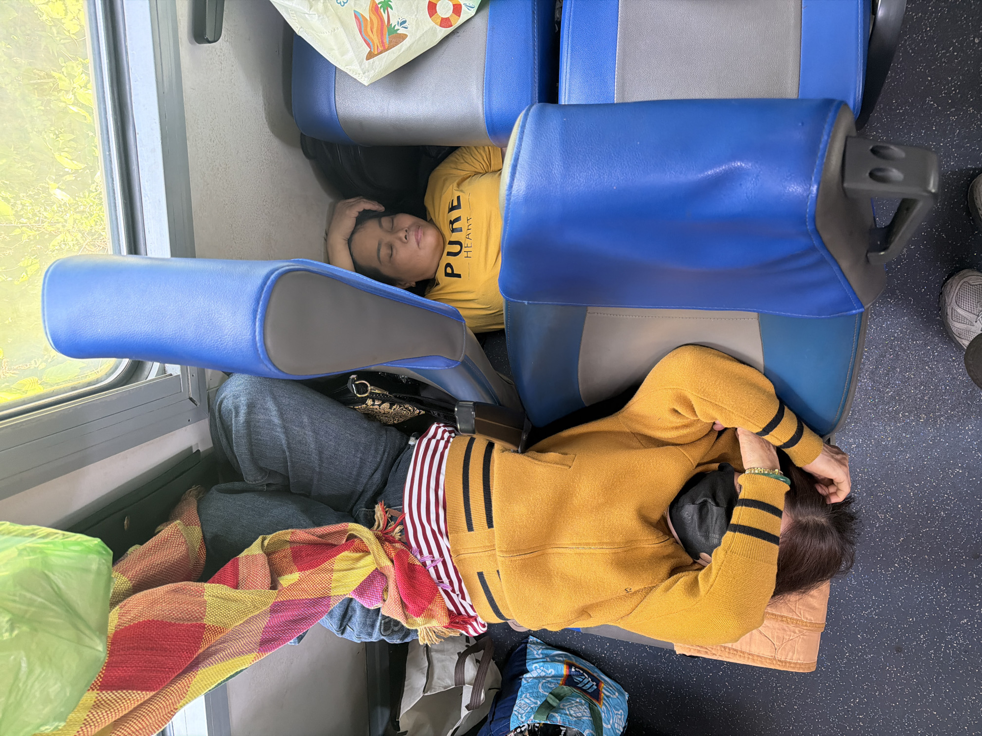 Train passengers sleep during overnight journey in Huế, Vietnam