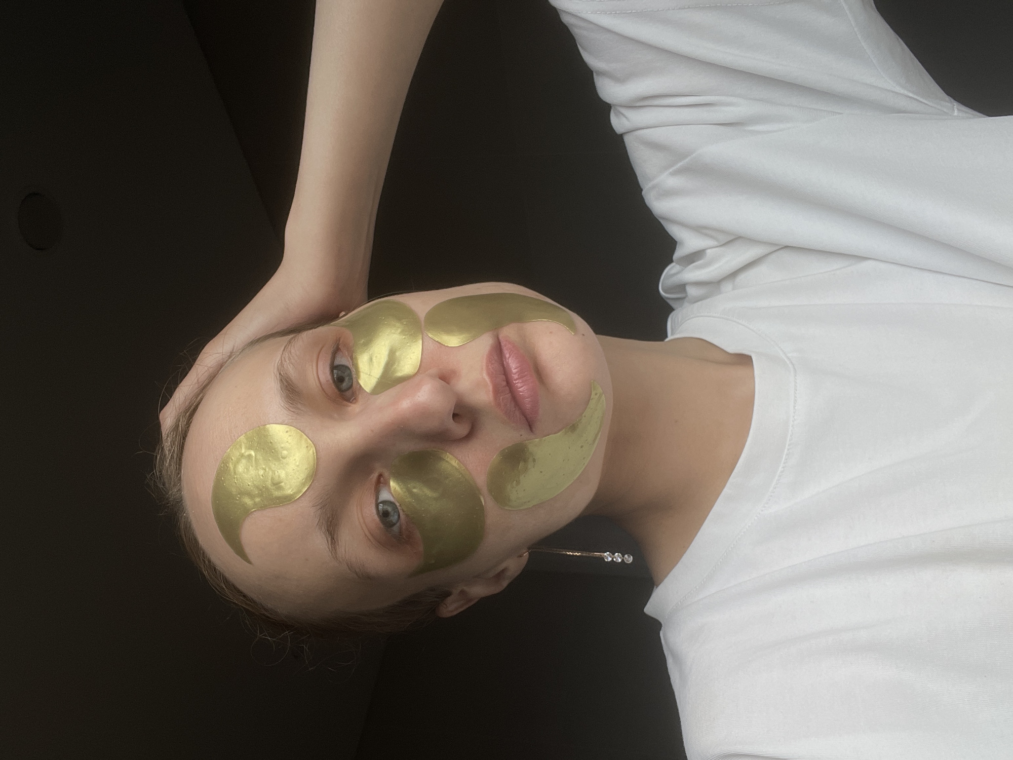 Woman takes bathroom selfies wearing gold facial patches
