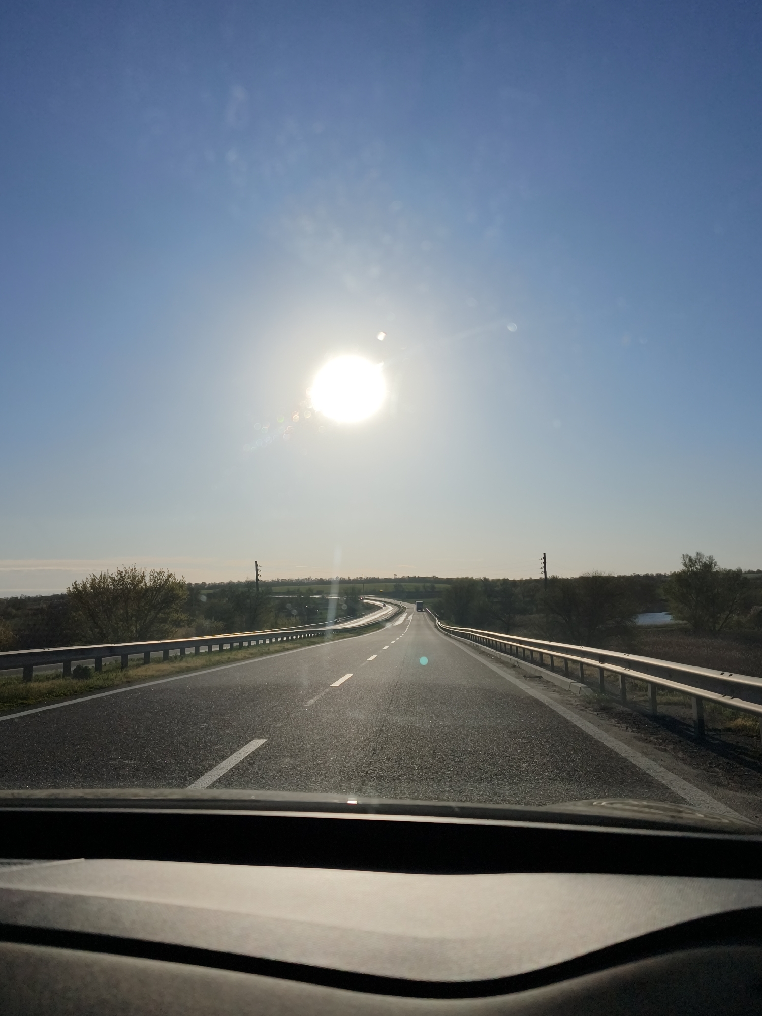 Two people drive through Malosofiivka under clear morning skies