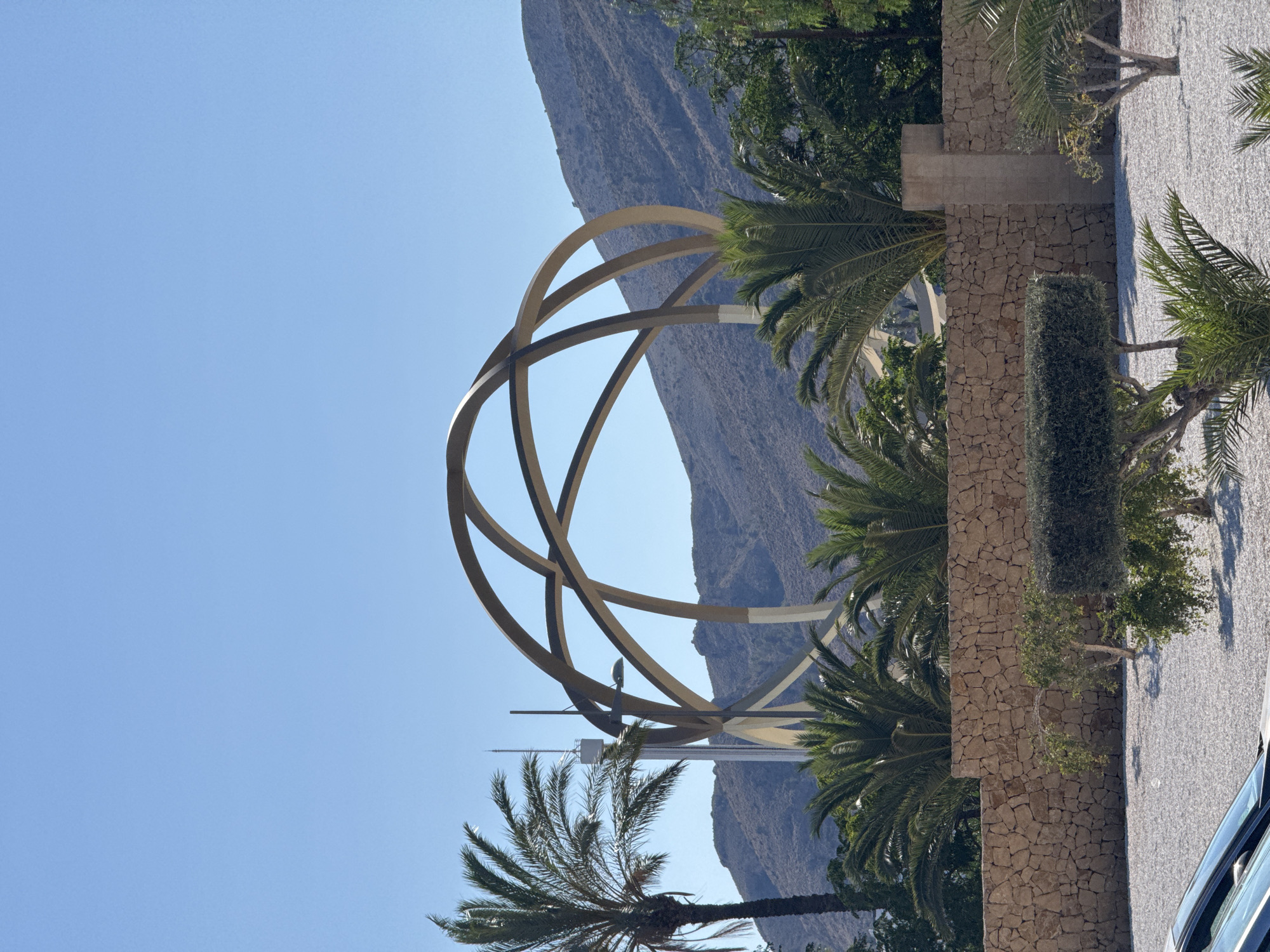 Benidorm's skyline, sculptures, and landscaping on a sunny afternoon