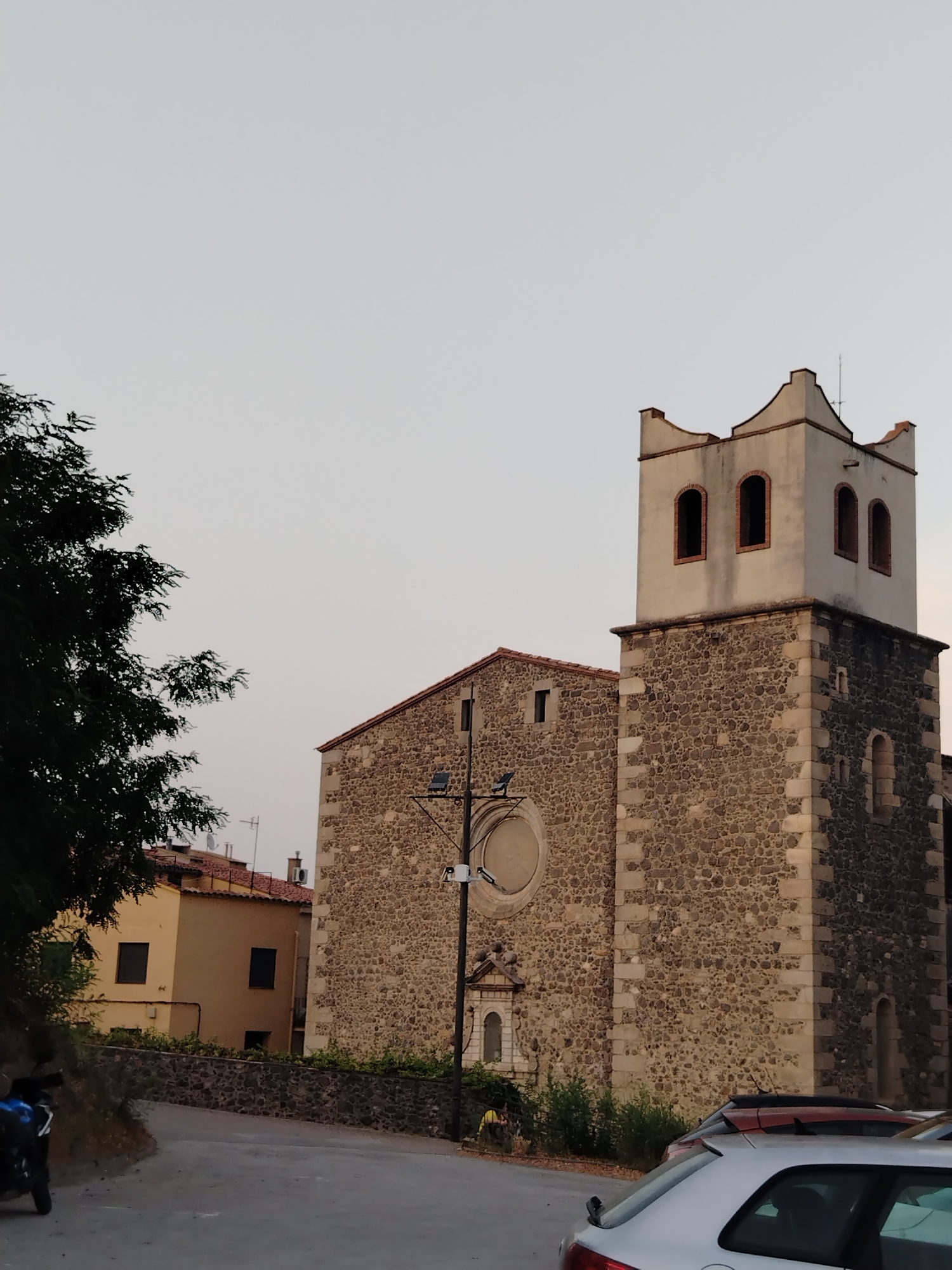 Stone church and hillside views in Hostalric at dusk