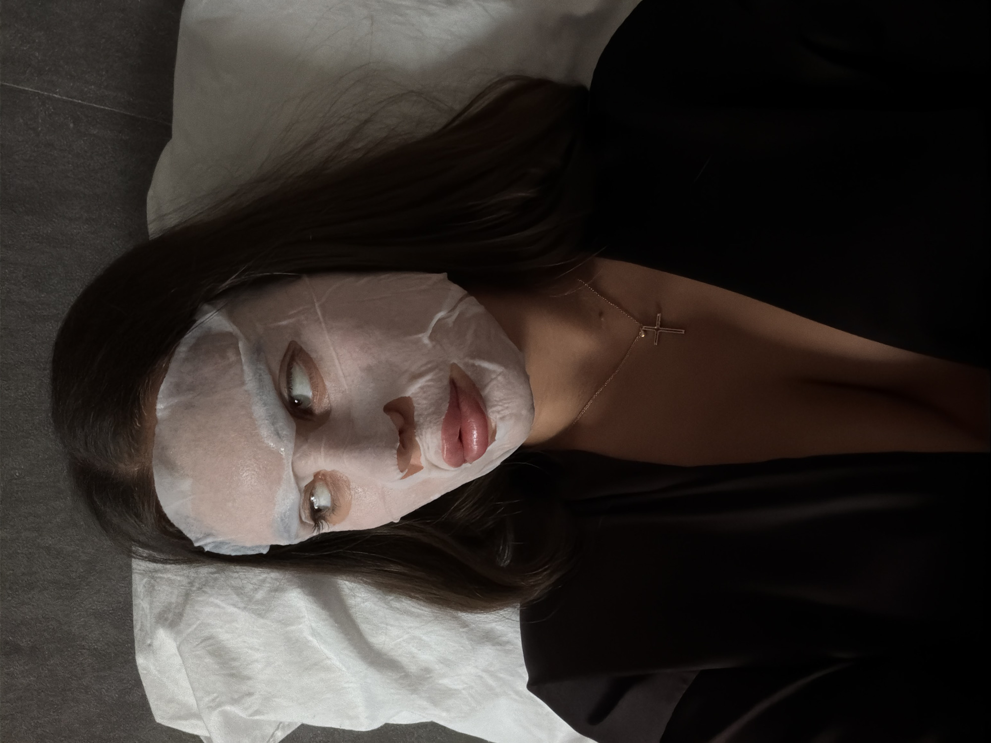 Woman applies facial mask during late-night skincare routine in Krasnoyarsk
