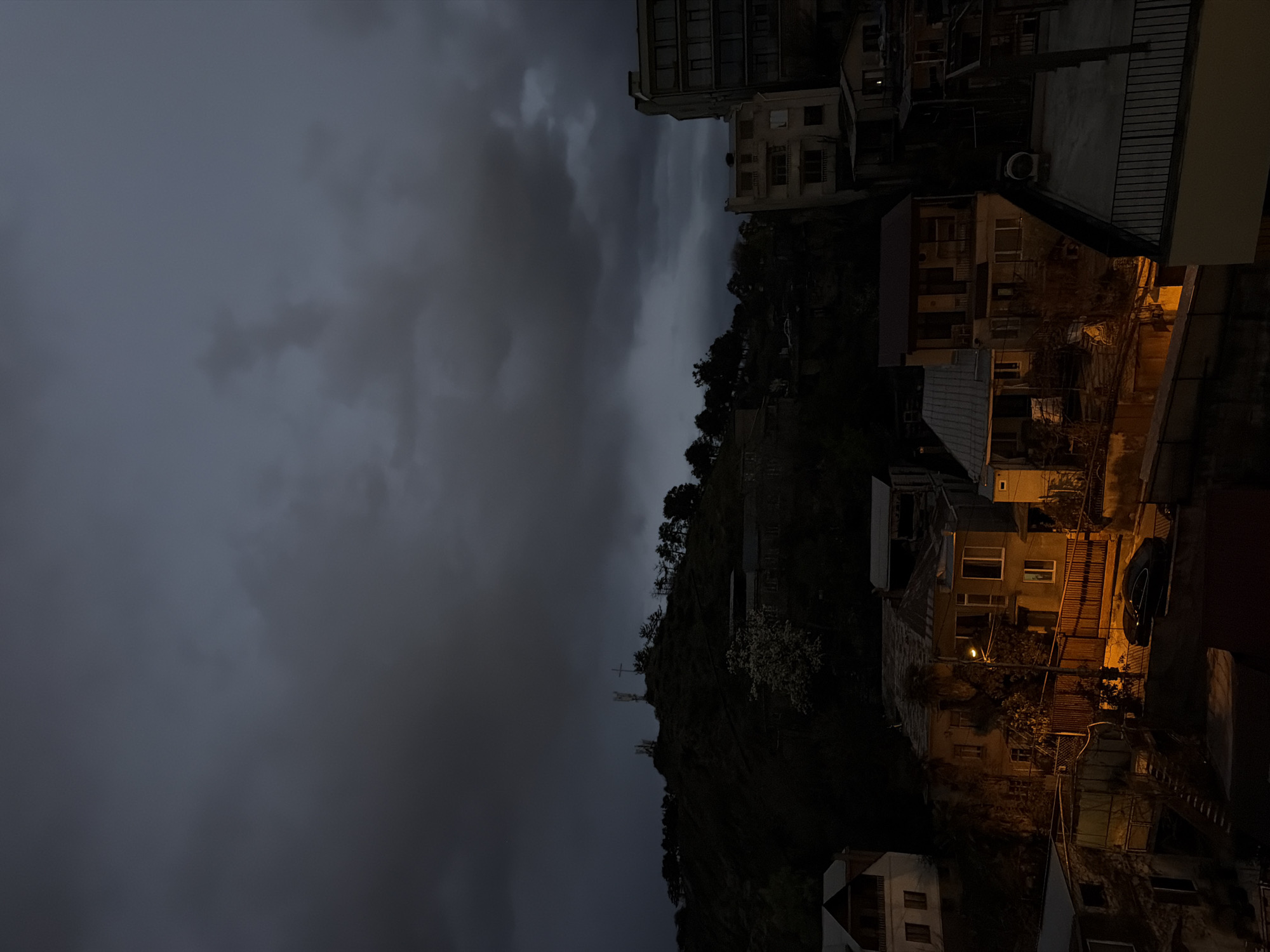 Nighttime hillside buildings illuminated in Tbilisi, Georgia