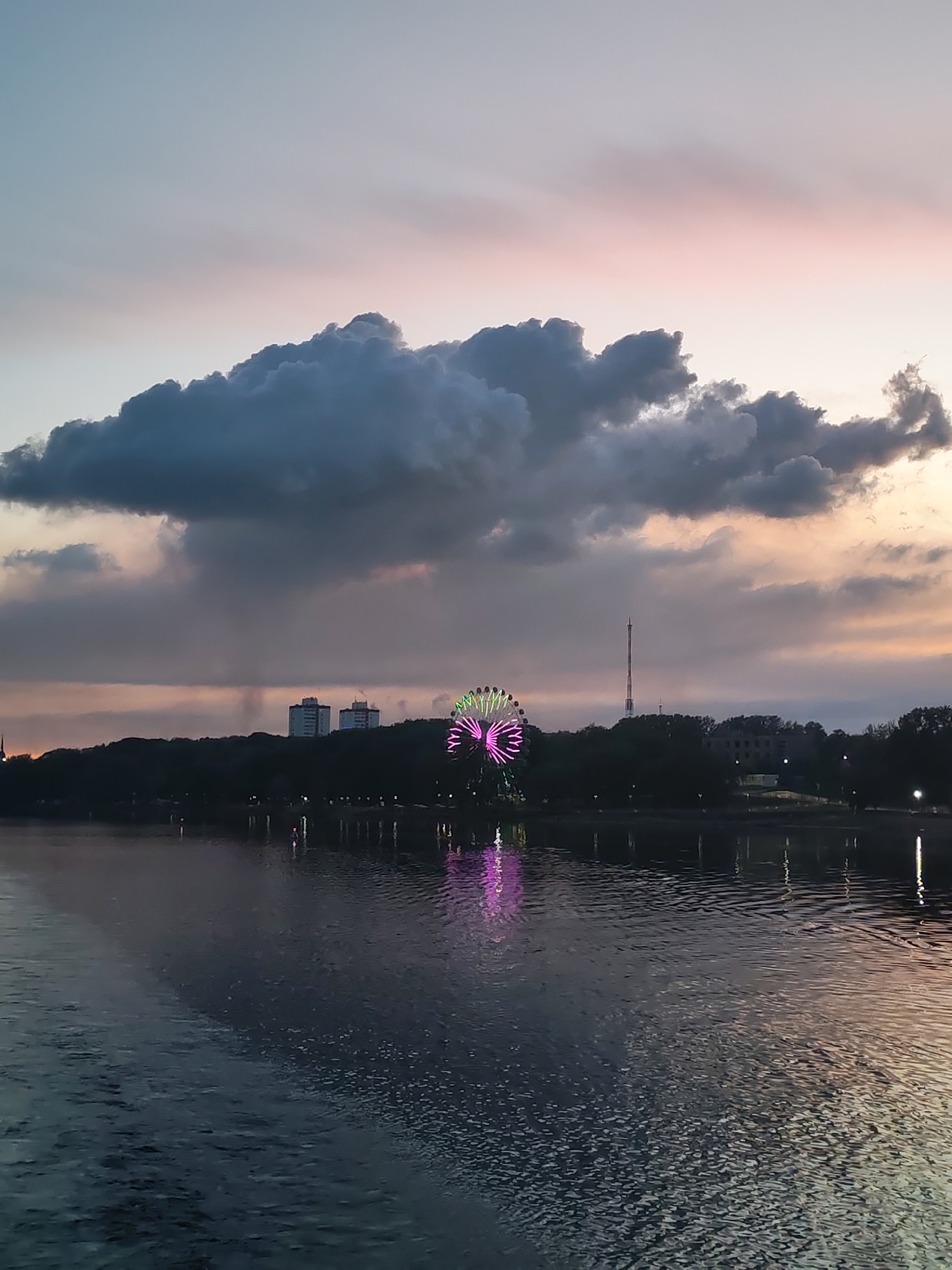 Lit Ferris wheel reflects in Cherepovets waters at twilight