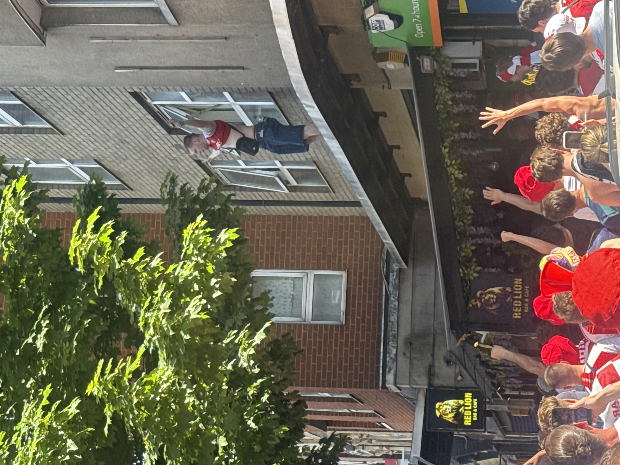 Arsenal fans celebrate outside London pub, supporters climb rooftops