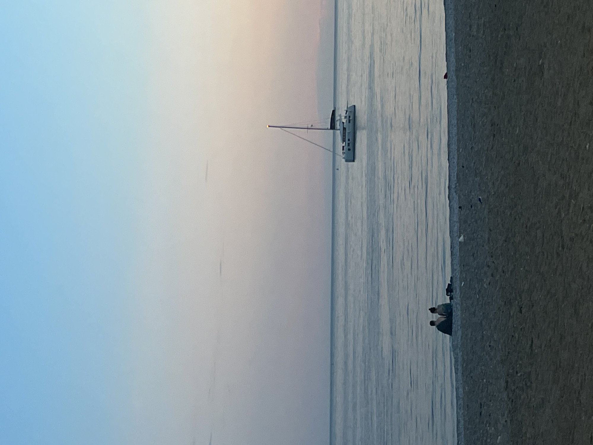 Twilight captured along Budva's Adriatic coastline with sailboats and city lights
