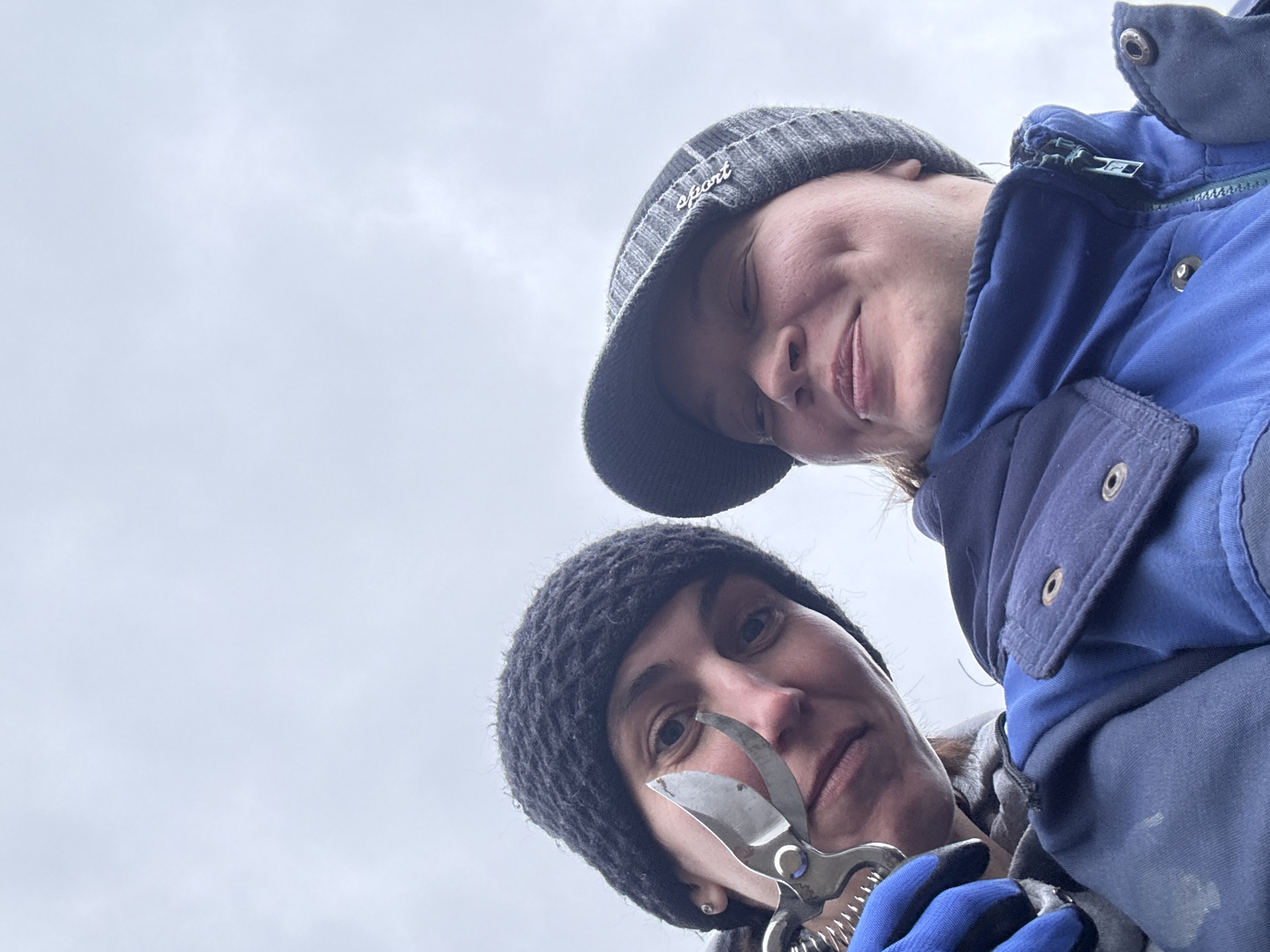 Two people take selfies in Russian village under overcast sky