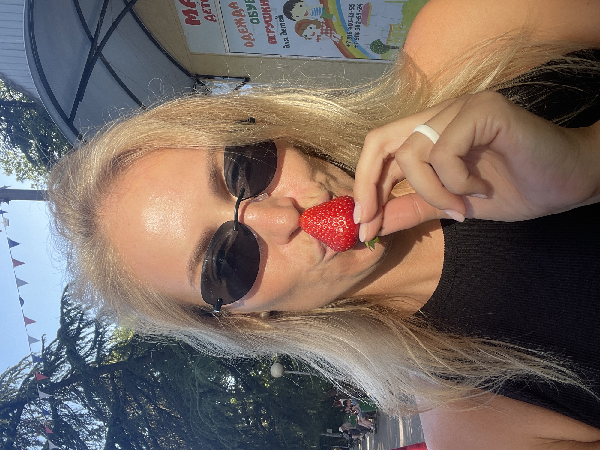 Woman enjoys strawberries, sightseeing during afternoon in sunny Sochi