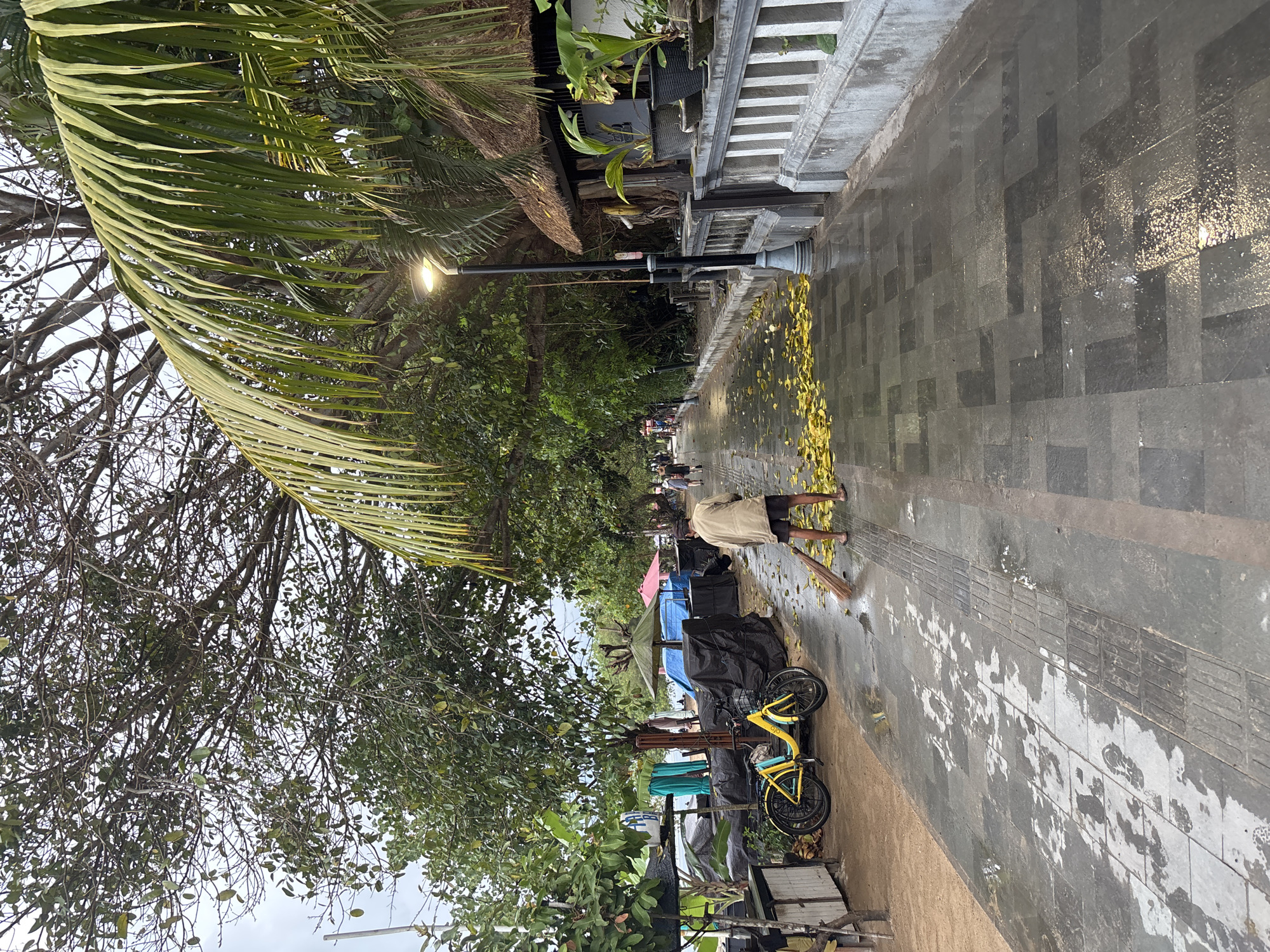 Morning beach life documented across Denpasar waterfront under cloudy skies