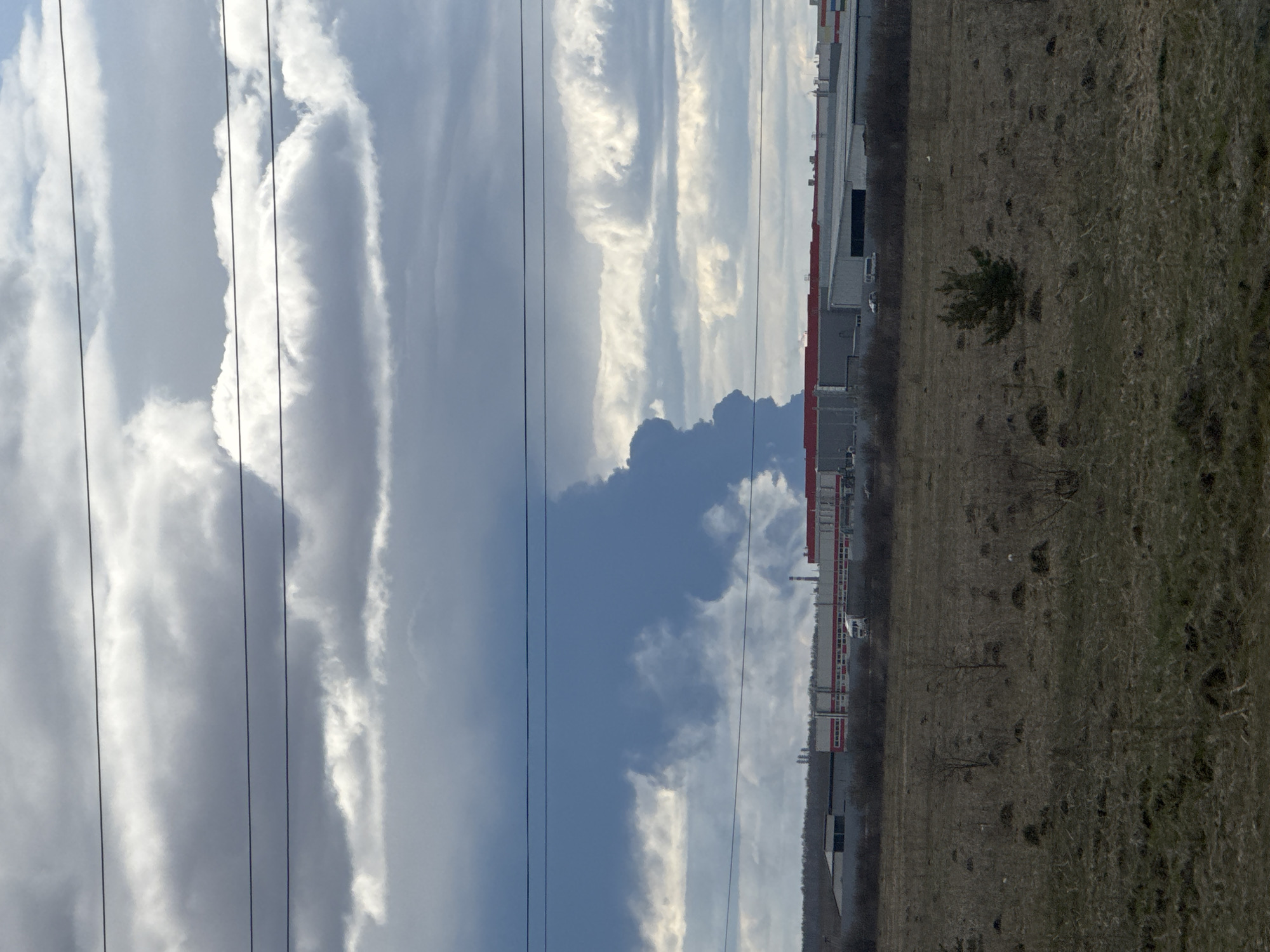 Dramatic cloudy skies photographed over Zamulyanka industrial-rural landscape