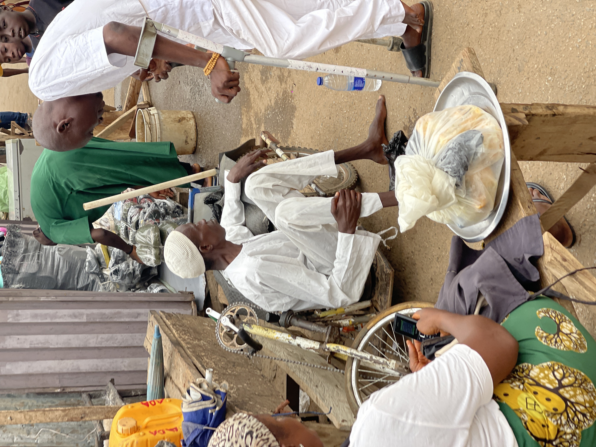 Person rests among bicycle parts in Kuchingoro, Nigeria