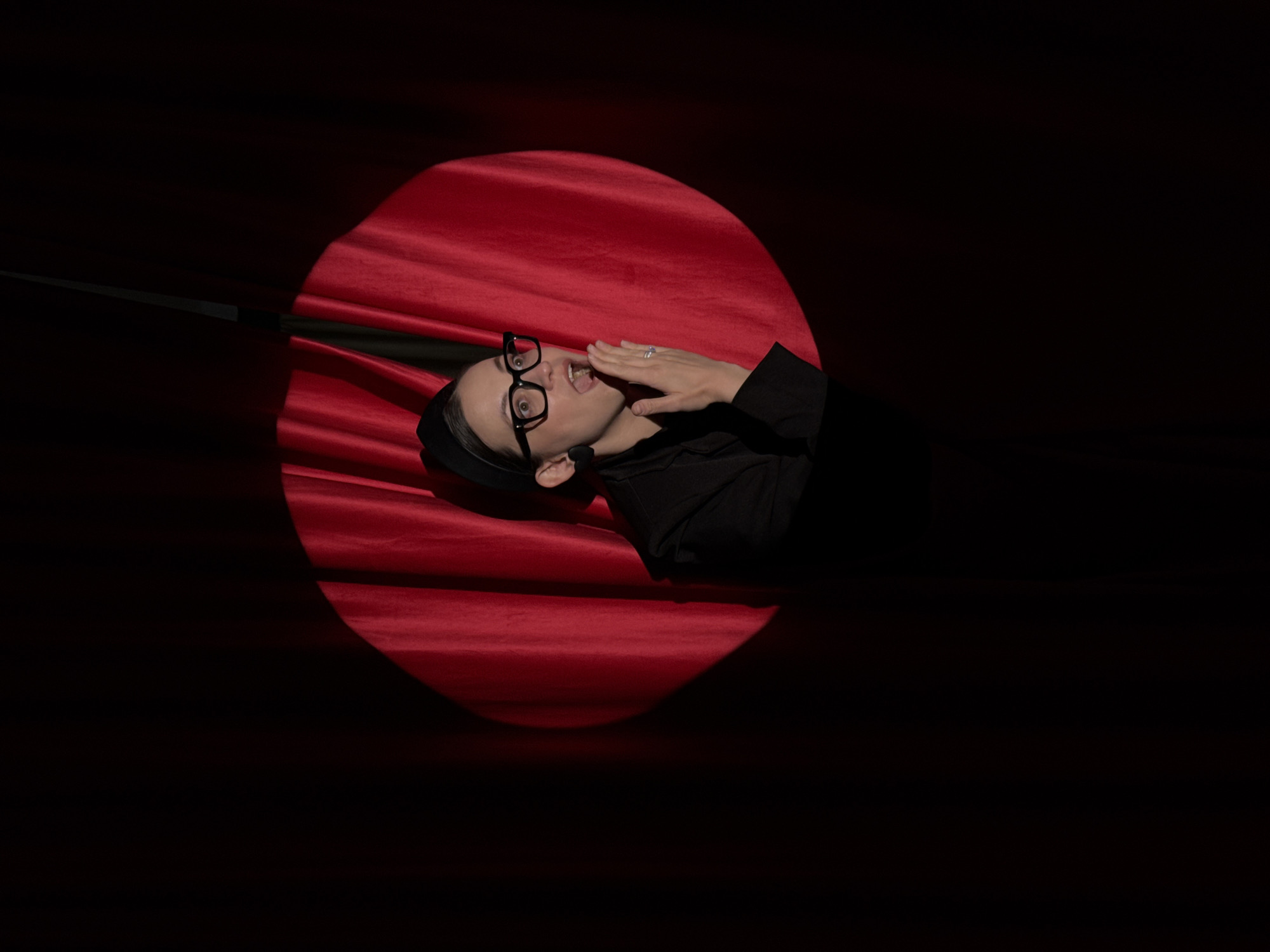 Person spotted in spotlight on red surface in Chaikovsky