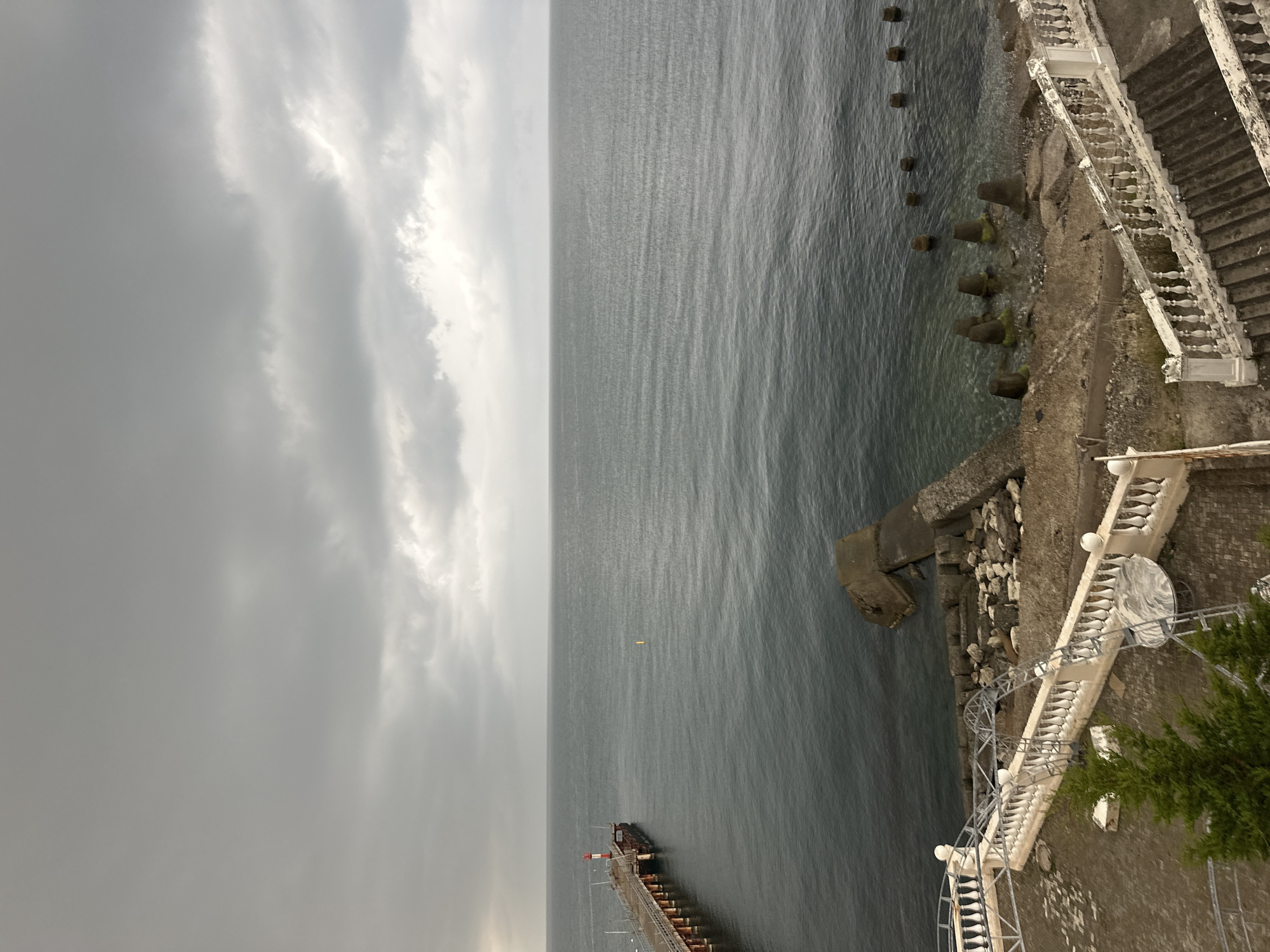 Overcast coastal scene: pier, beacon, and grey sea