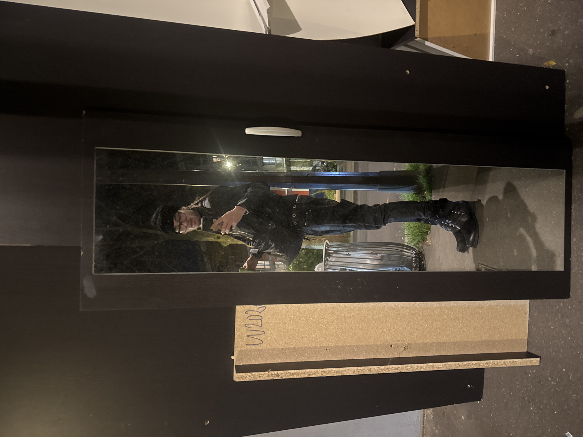 Person in black attire reflected in Paris wardrobe mirror