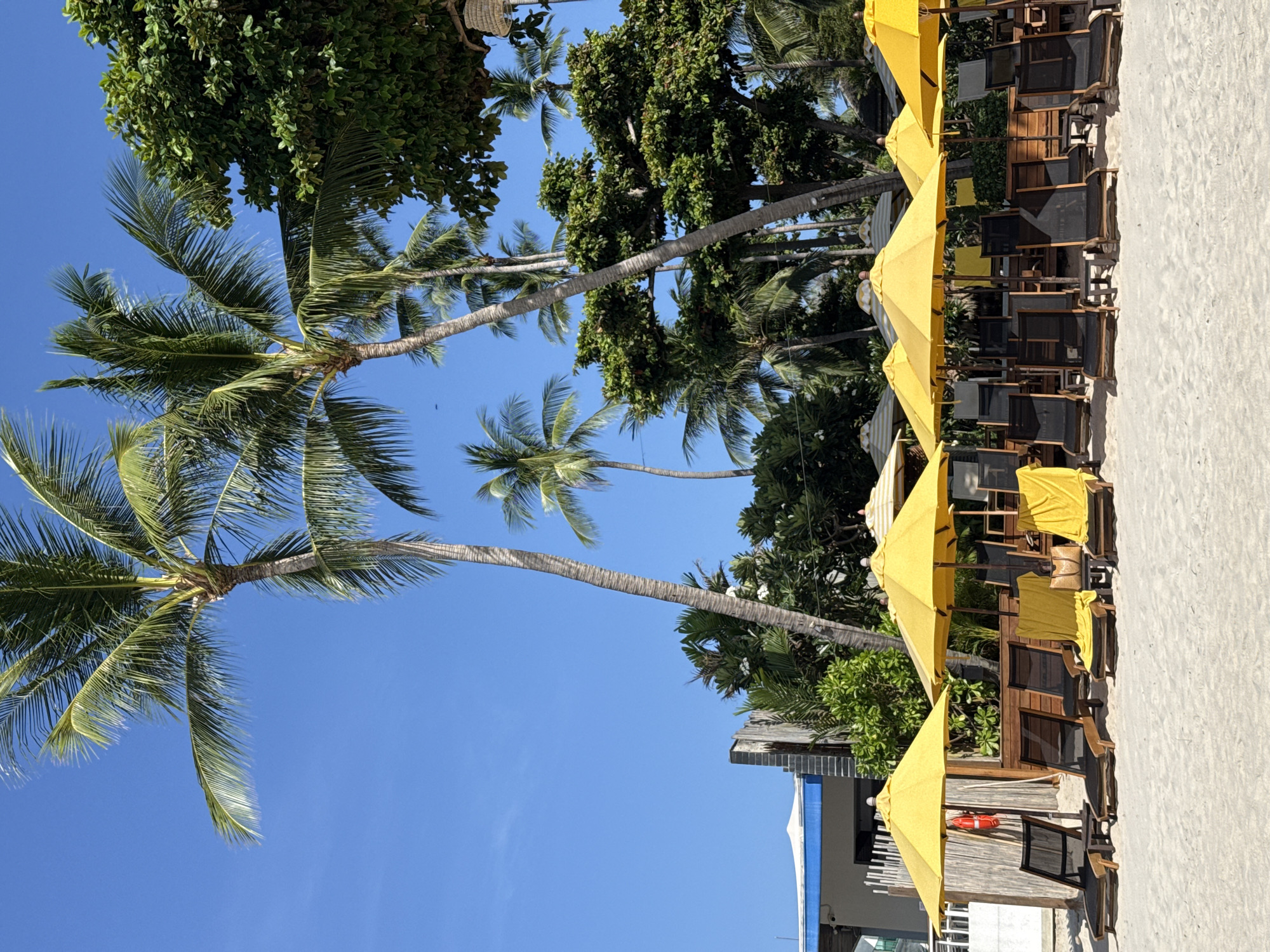 Ko Samui beach in full midday sun, boats and jet skis out