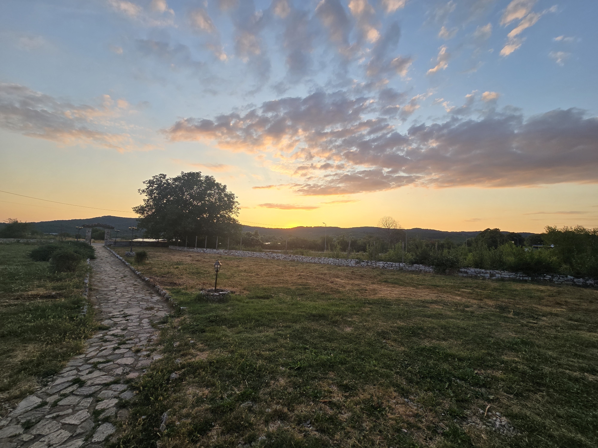 Sunset over a rural stone-path property in Malko Tarnovo, Bulgaria