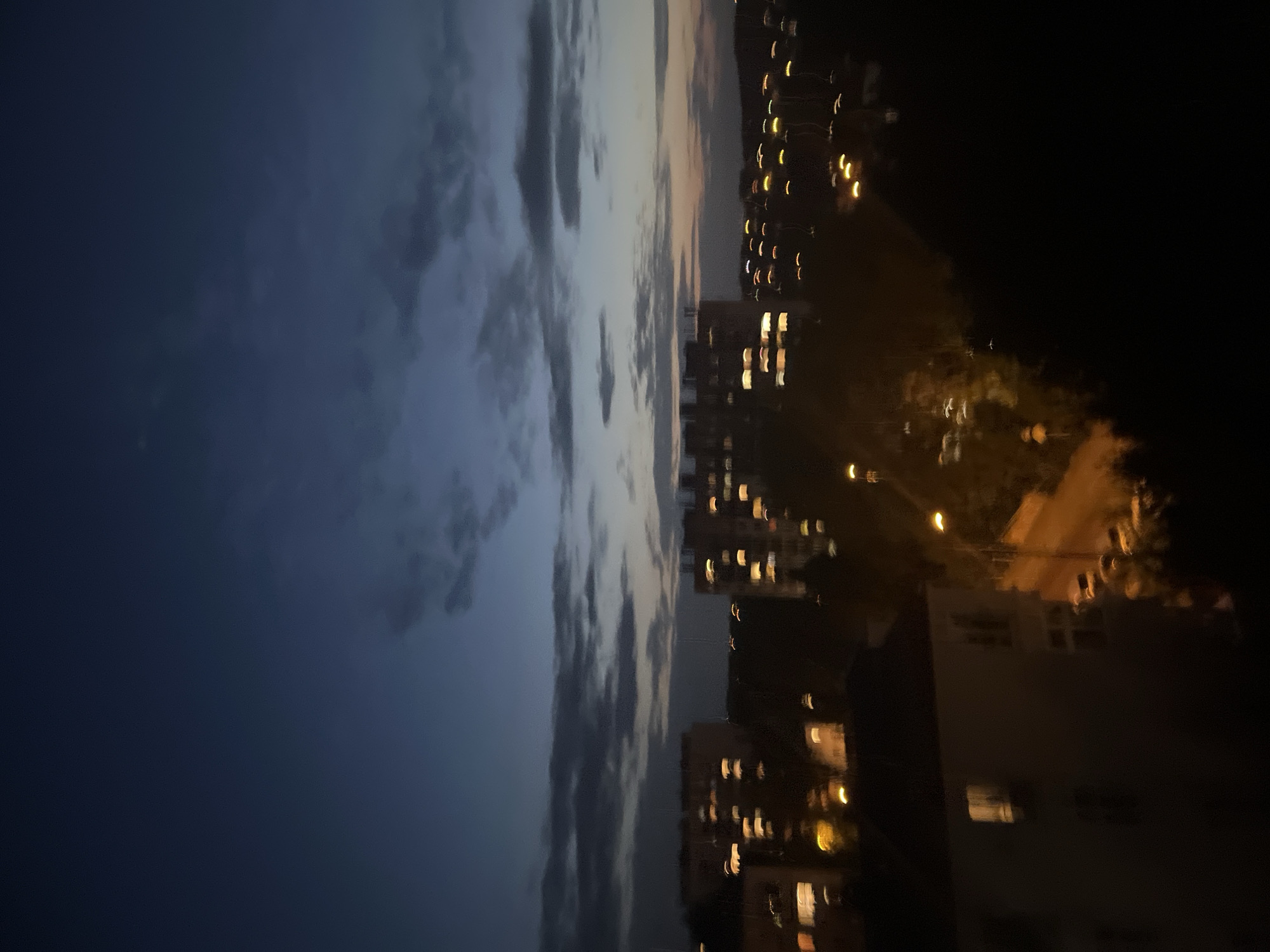 City skyline at dusk, lights coming on across the urban sprawl