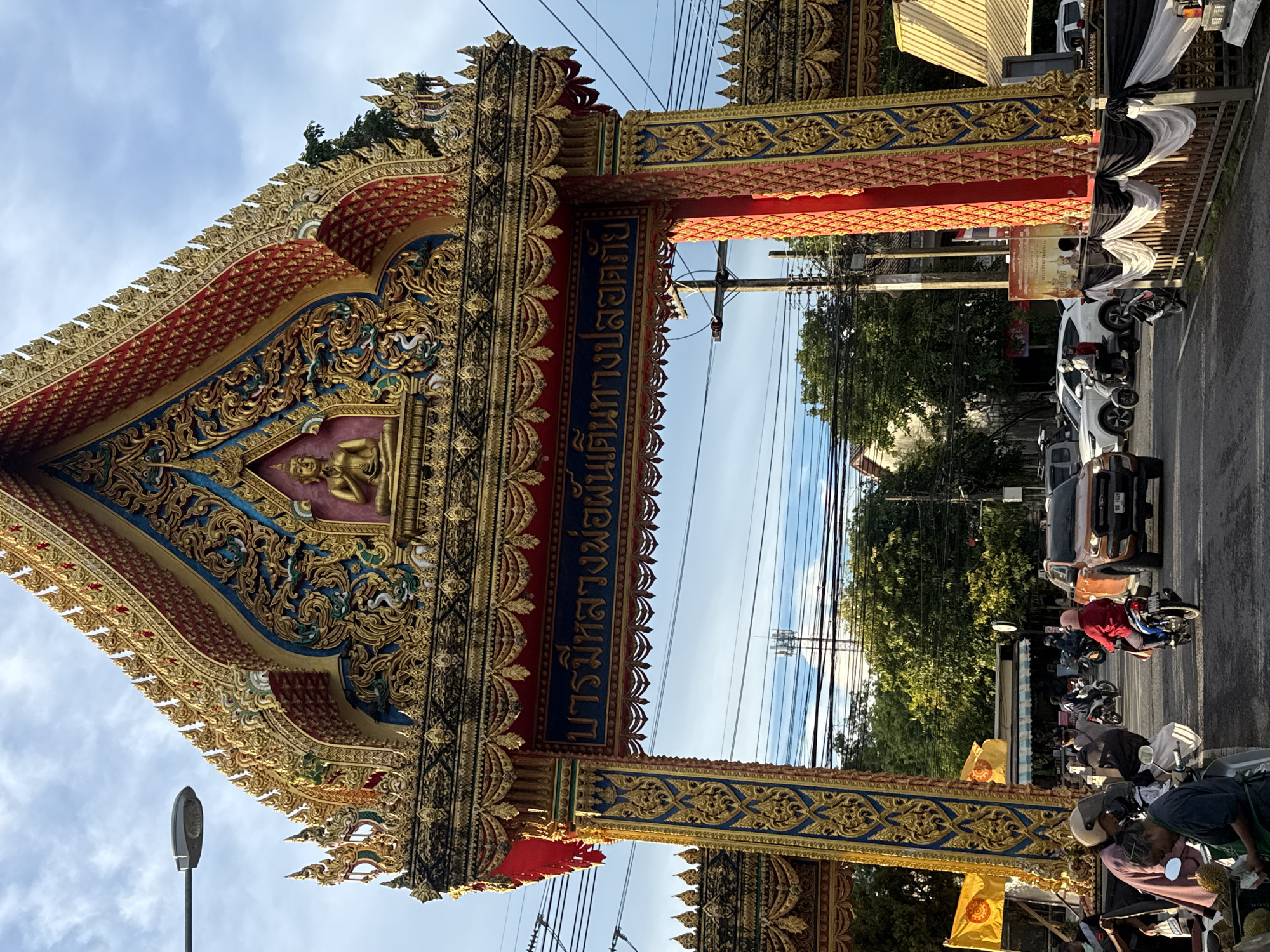 Ornate Buddhist gateway and street life in Si Sunthon