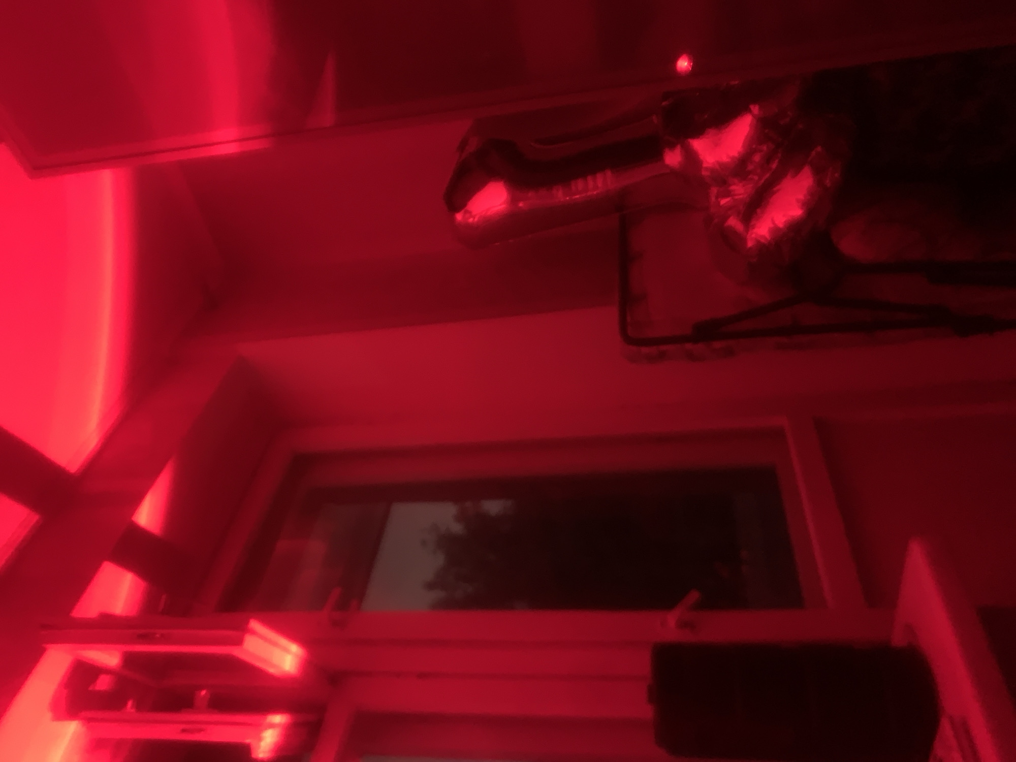 Red-lit indoor scene with balloon, person observed evening hours