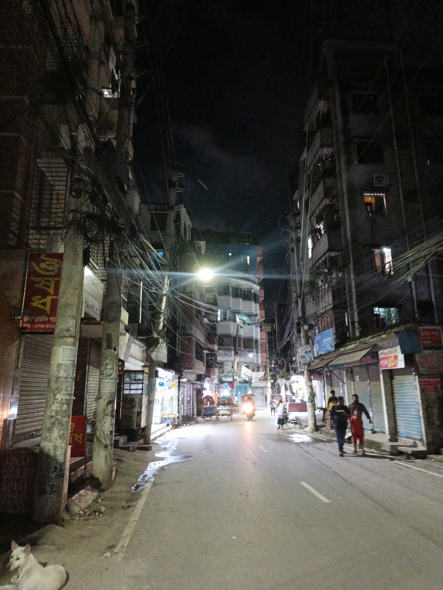 Night scenes along a busy commercial street in Dhaka