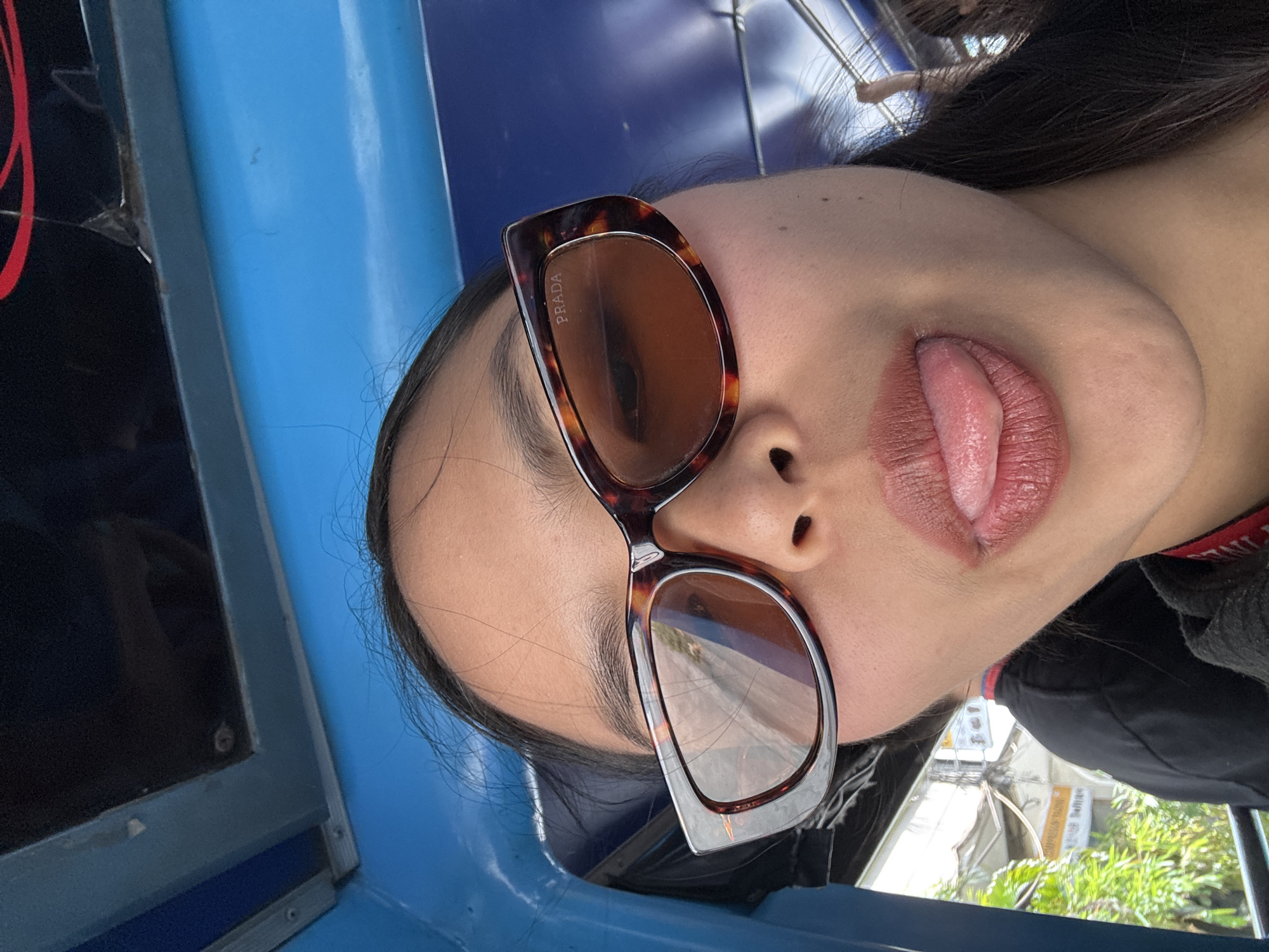 Person in Prada sunglasses poses playfully in Davao City