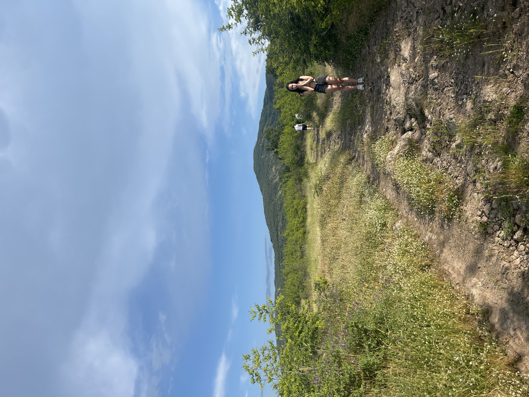 Woman stands on dirt path in Bulgarian village