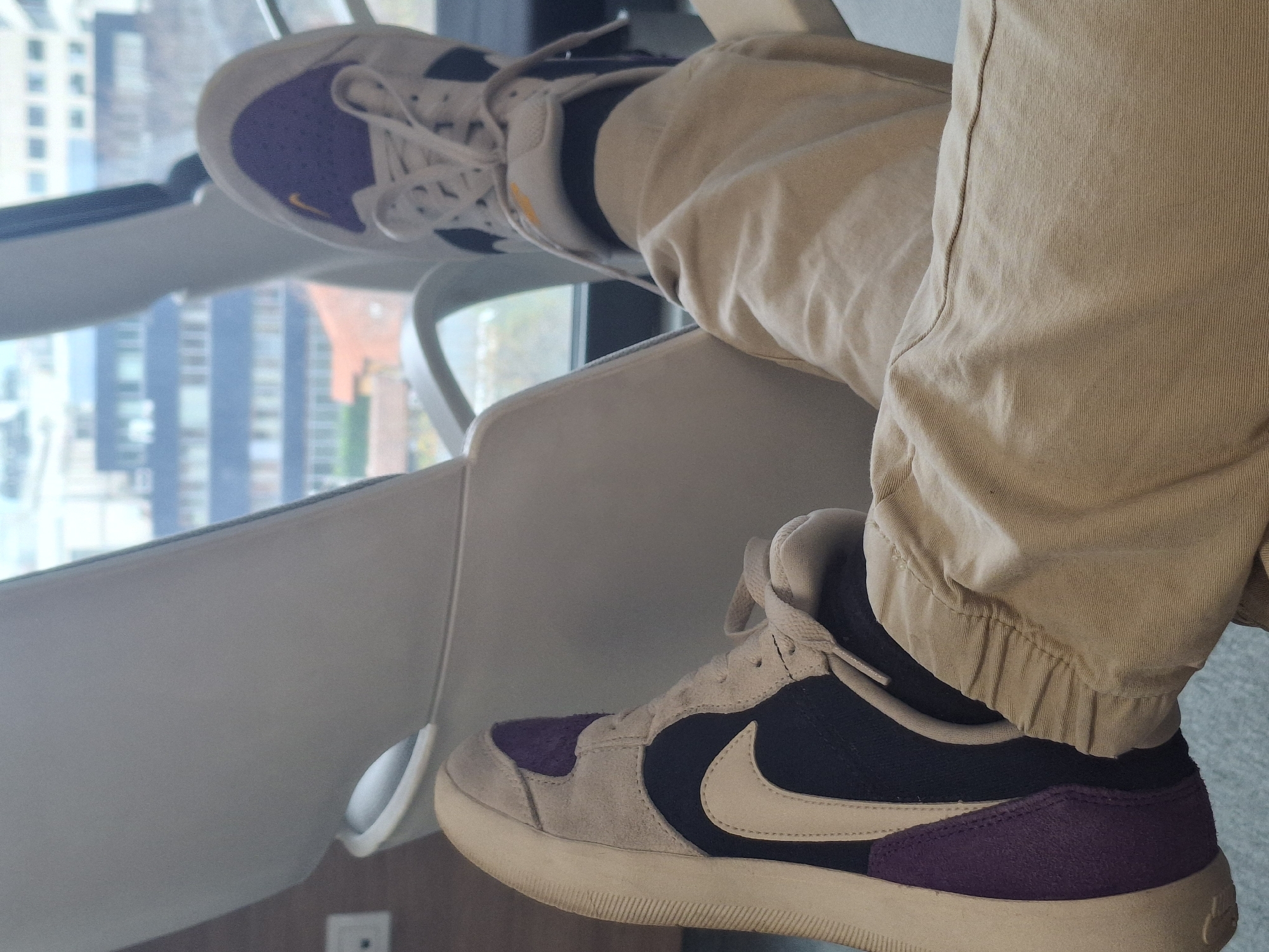 Person in Nike sneakers observed by window in Sofia