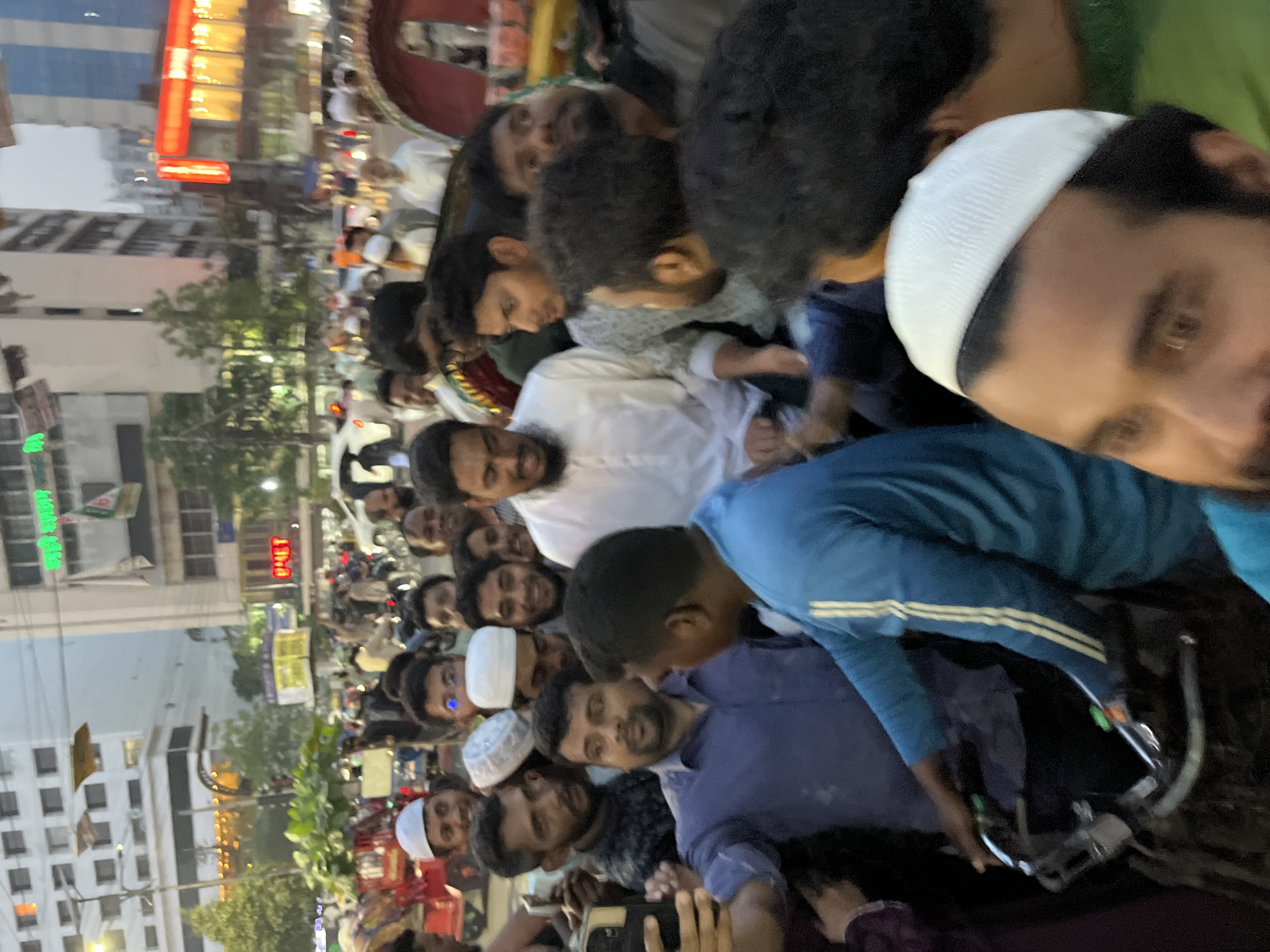 Large crowd in traditional dress gathers on Dhaka street