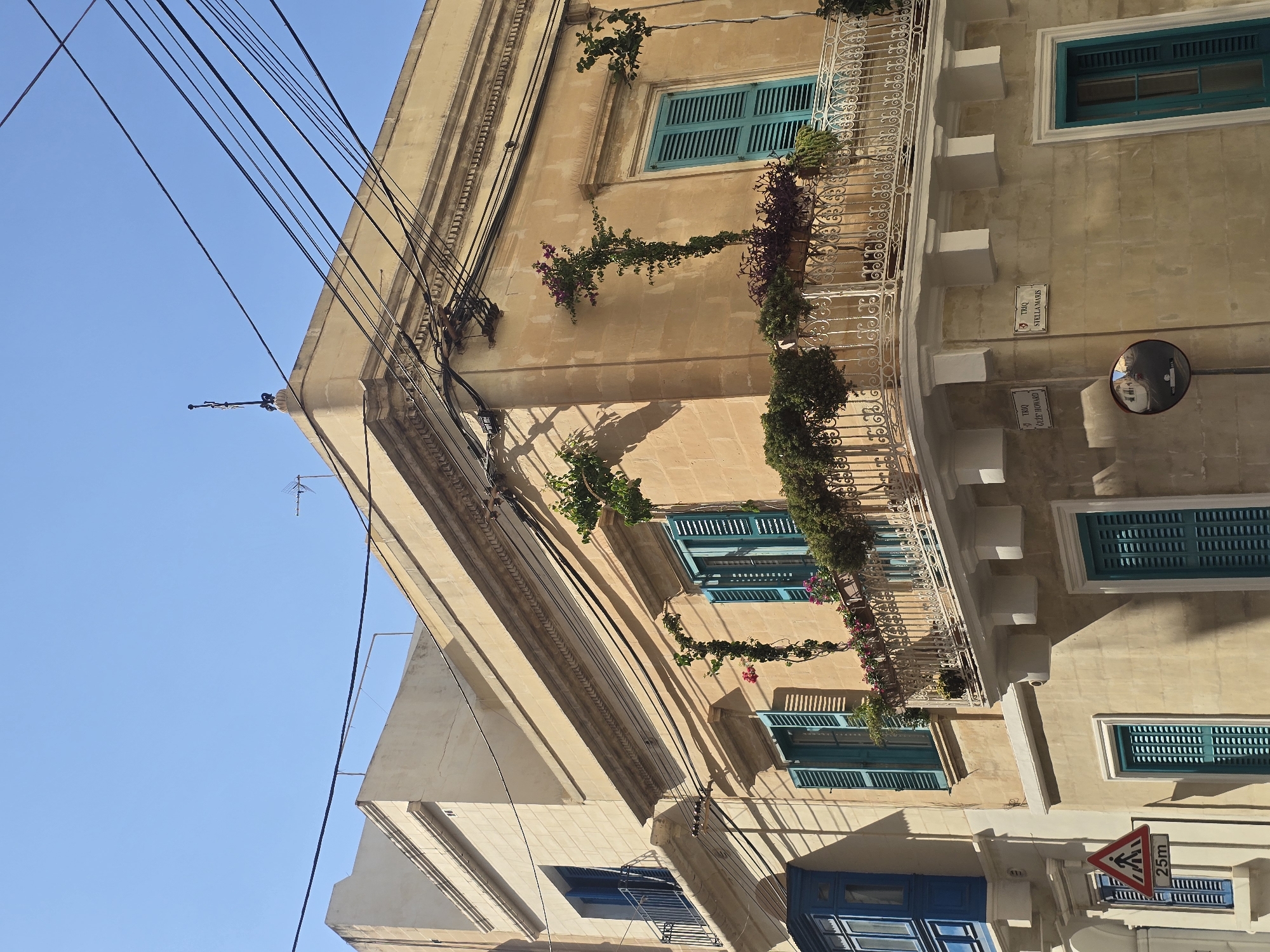 Sliema streetscape: balconies, stone facades, and a red scooter