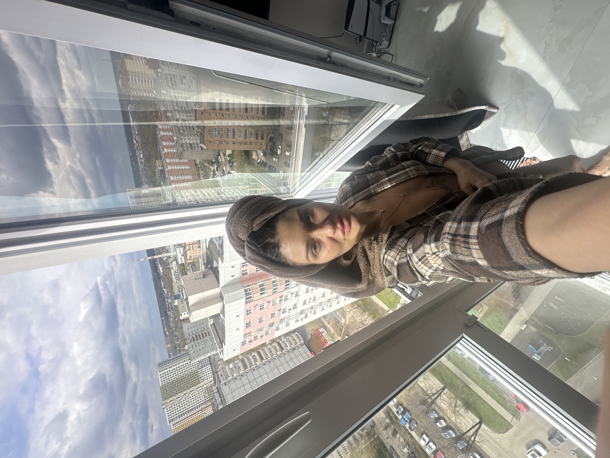 Woman in towel and robe observed near window in Moscow