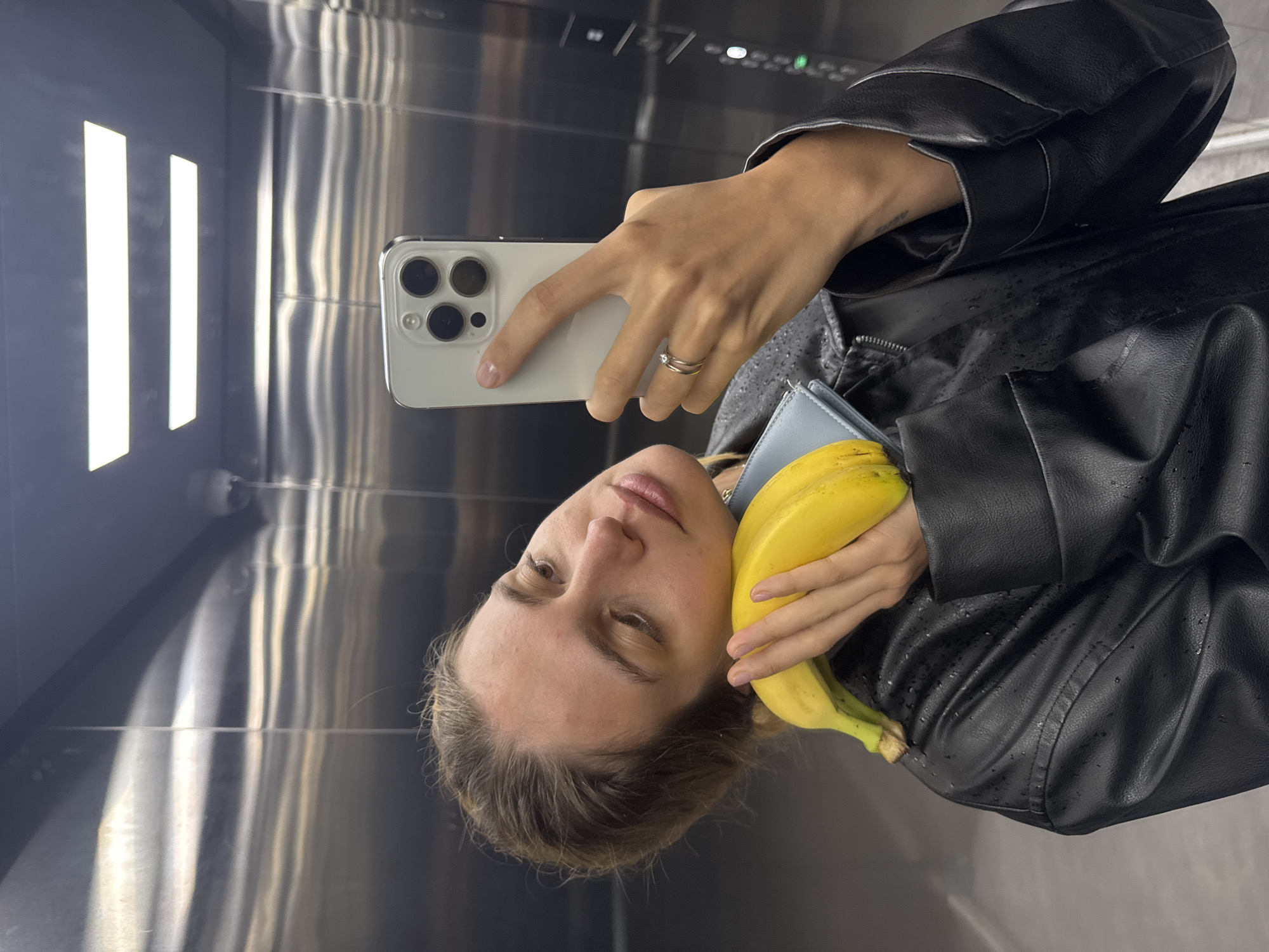 Woman takes banana selfie in elevator