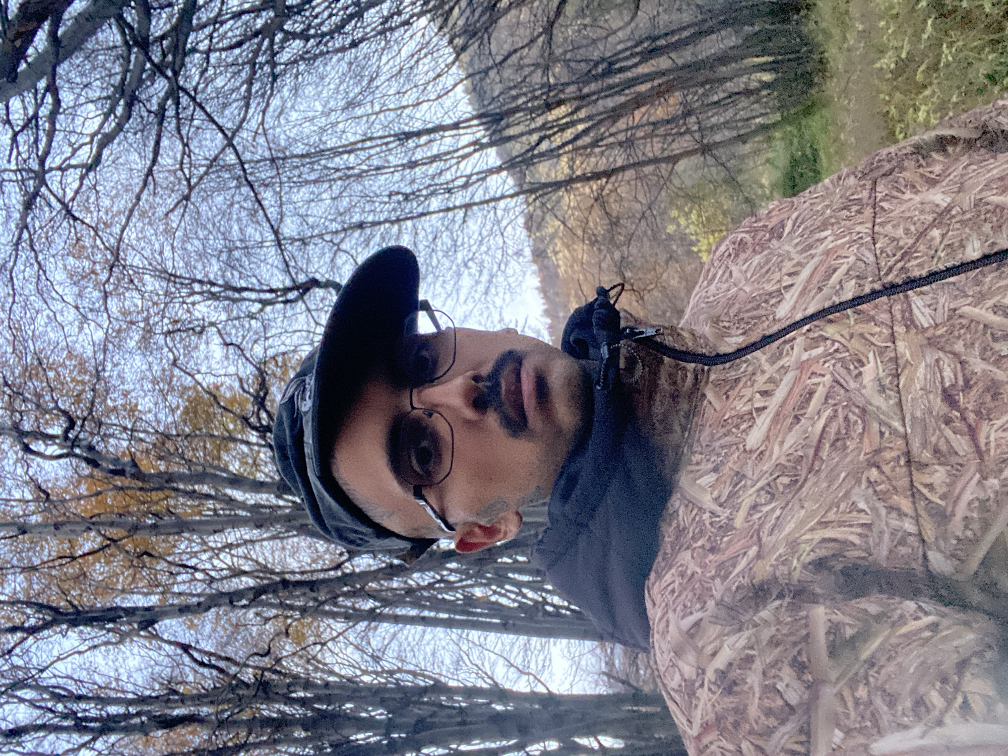 Person in camouflage walks through Ushuaia vegetation