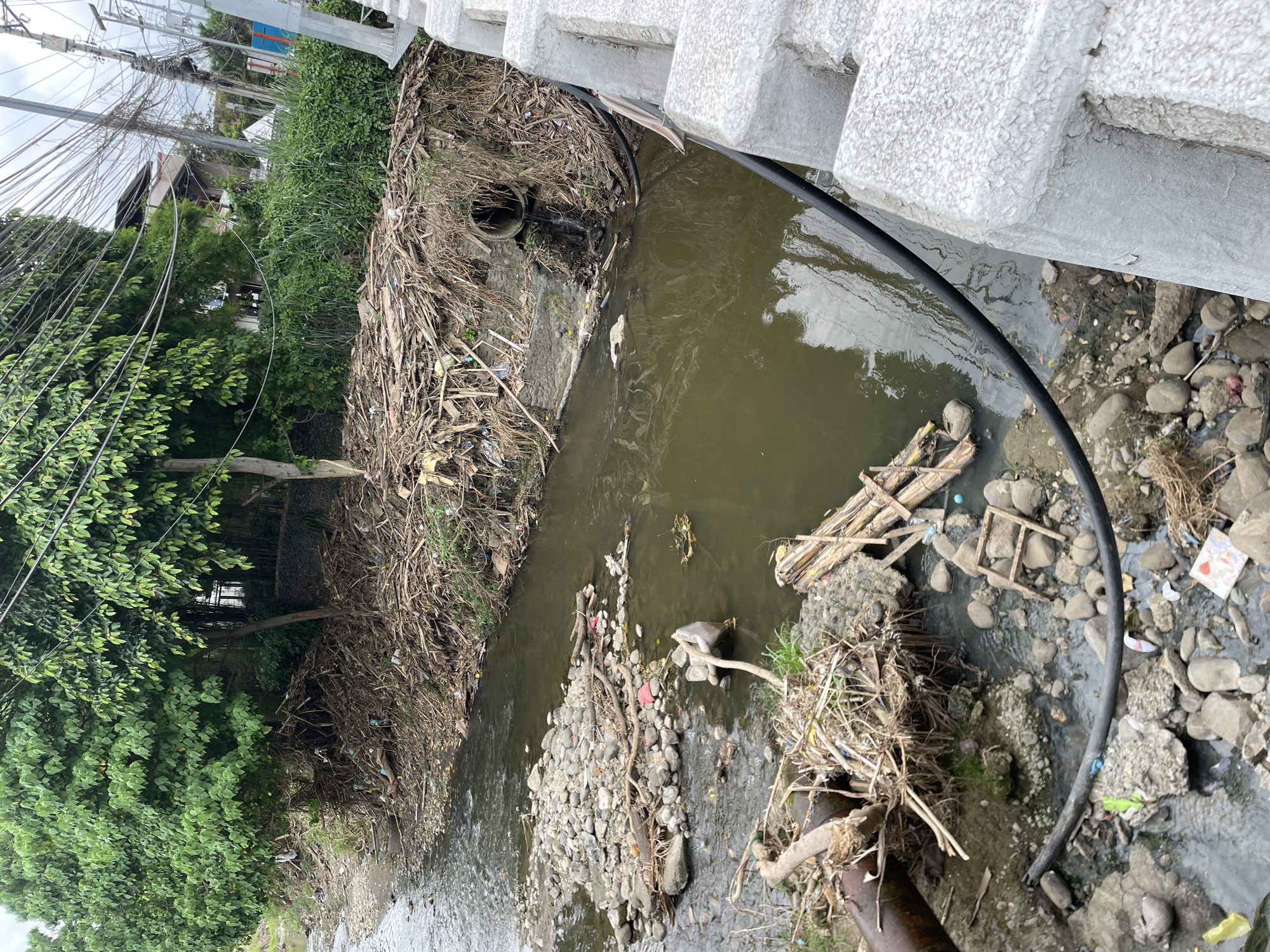 Polluted riverbank documented in Davao City amid normal traffic