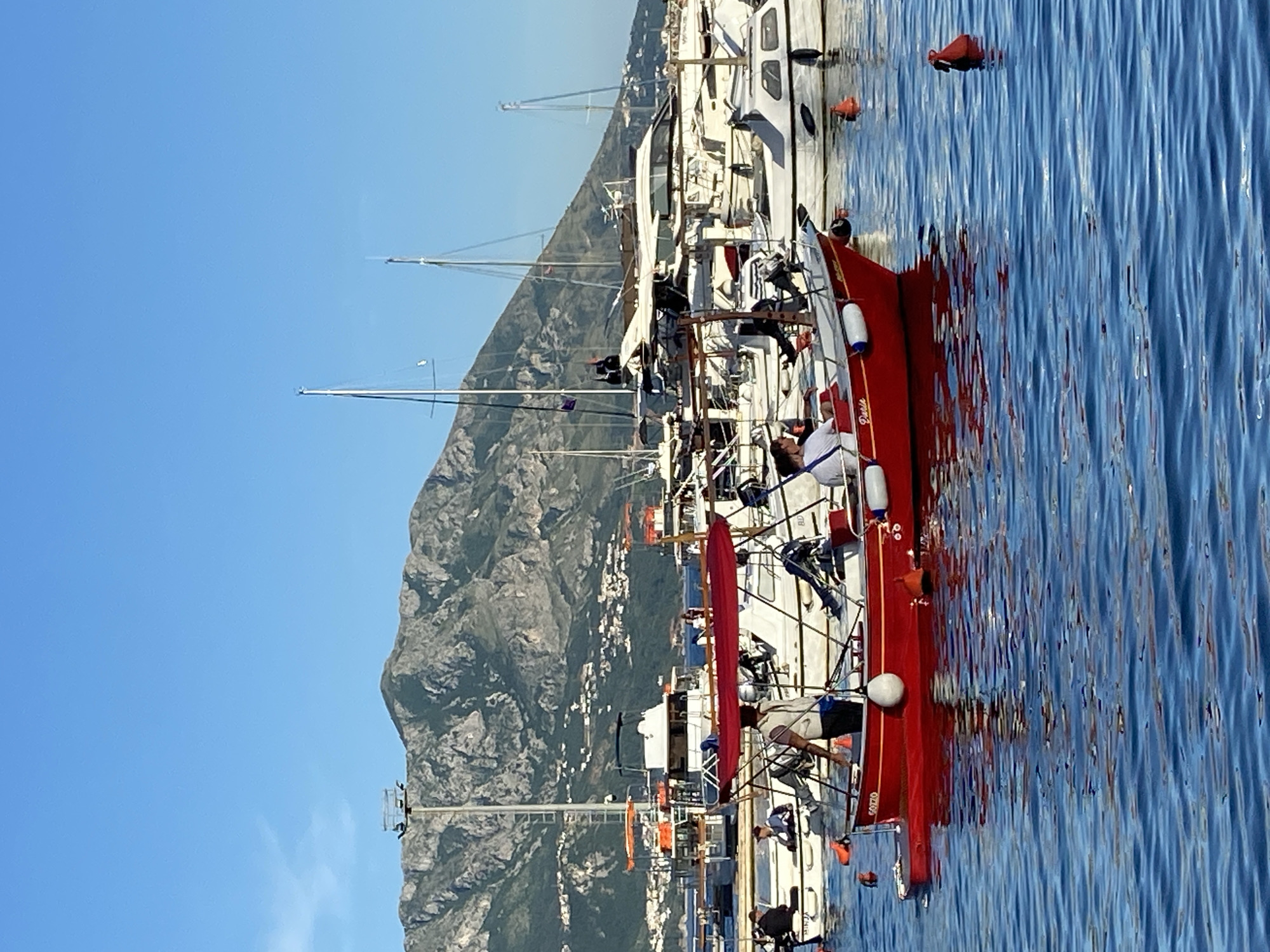 Budva waterfront activity captured with yachts, passenger boat, local cat
