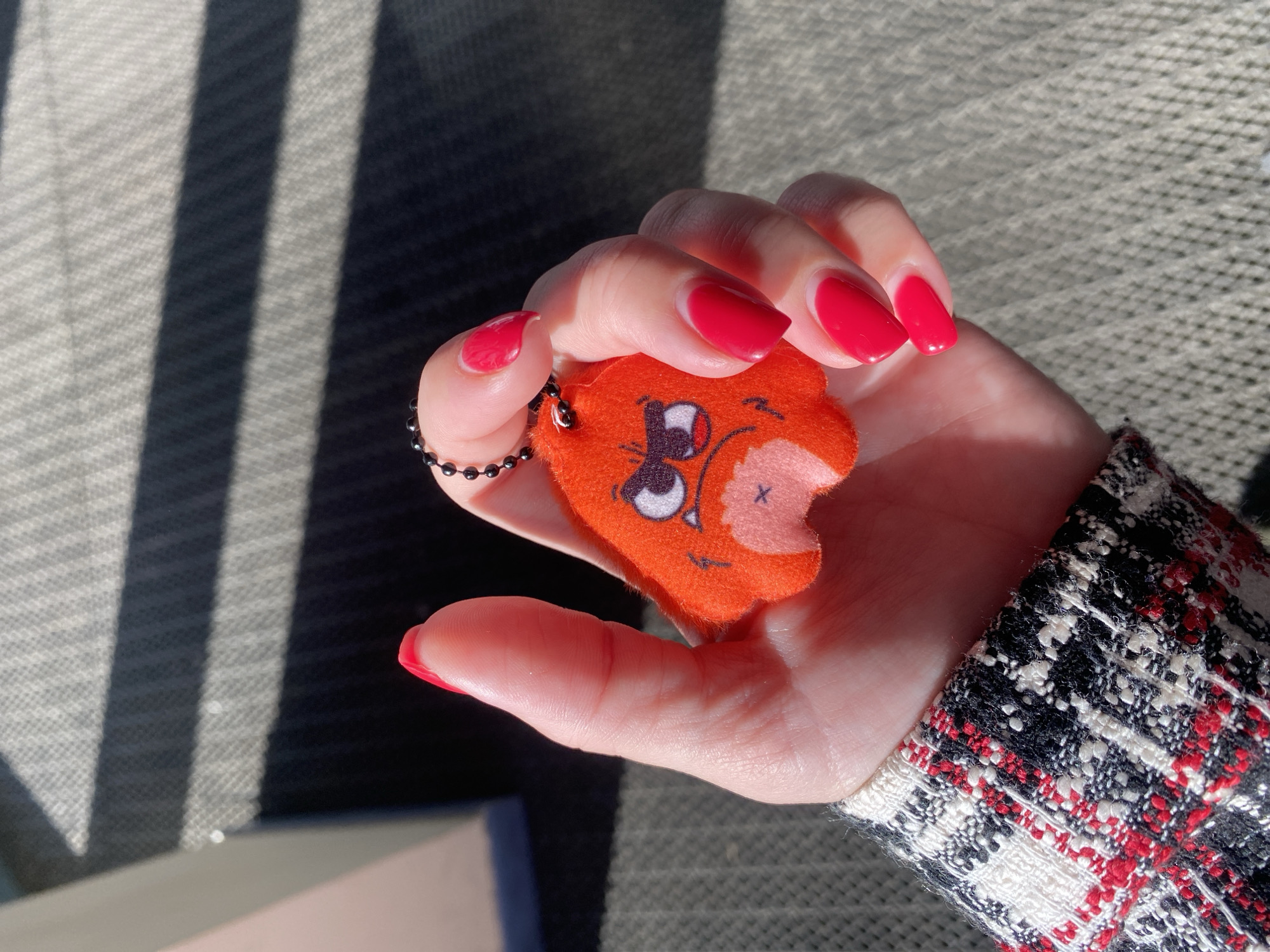 Person holds damaged orange plush keychain in Izhevsk