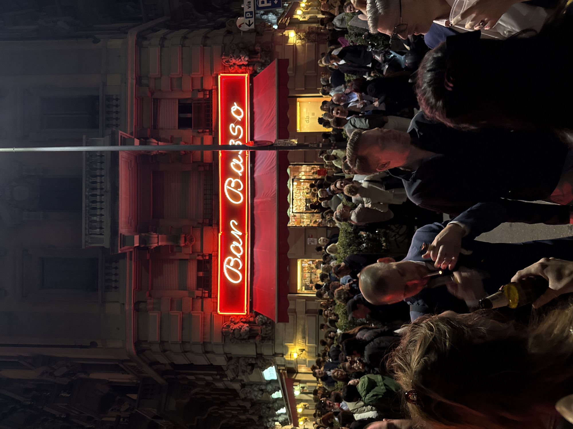 Crowds gather outside Milan's Bar Basso during evening hours