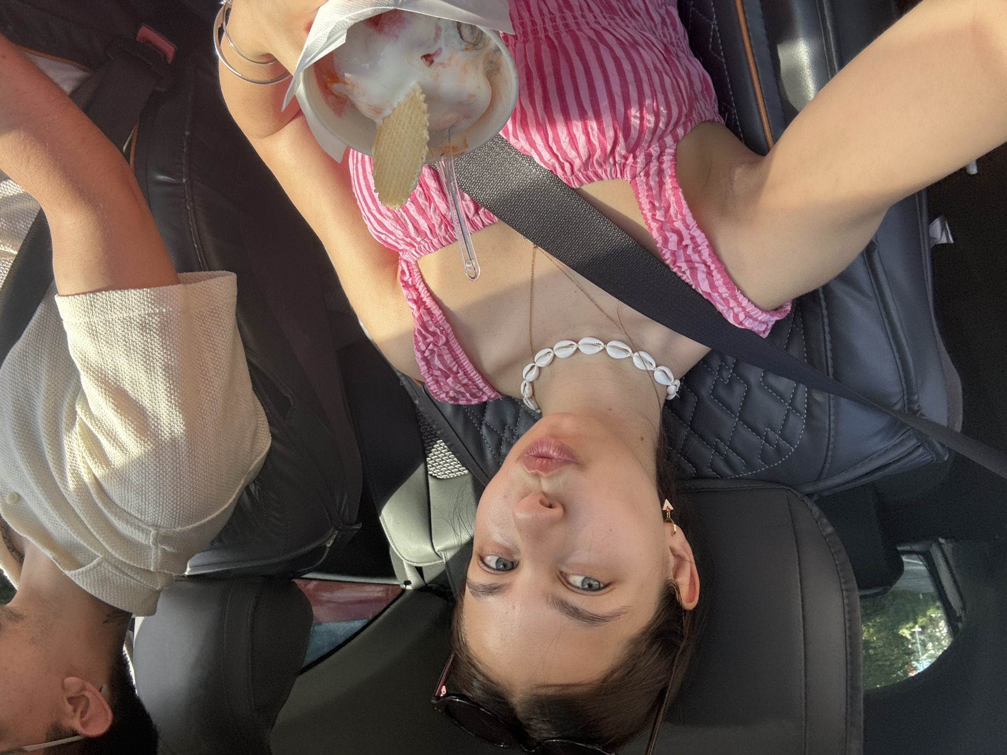 Woman enjoys ice cream, takes selfies in car