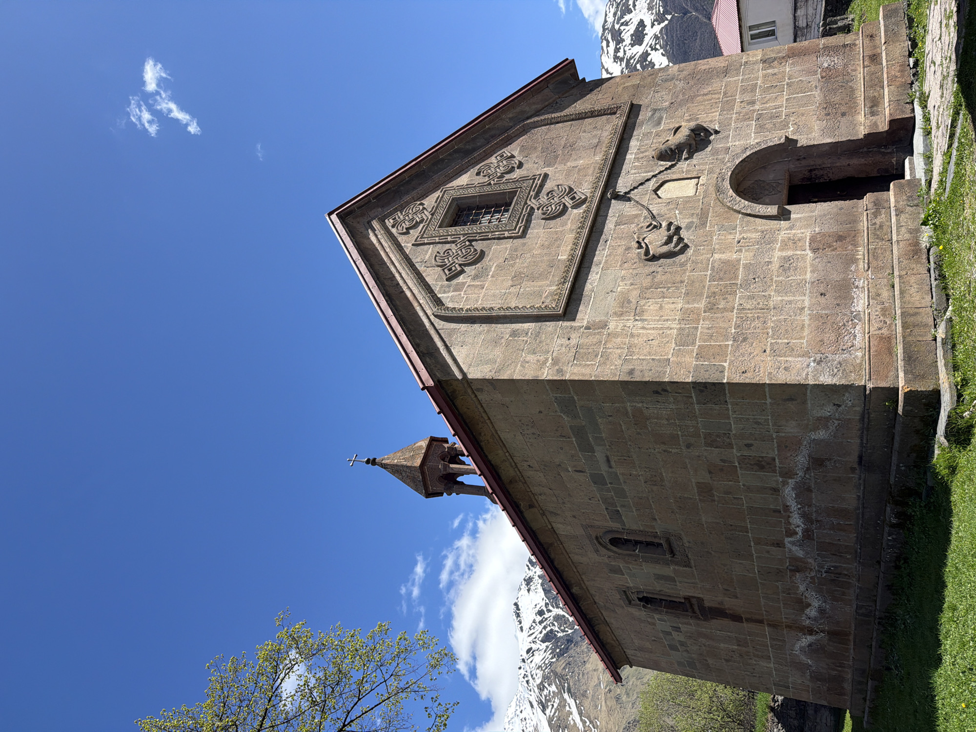 Tourist documents historic church and mountains in Stepantsminda, Georgia